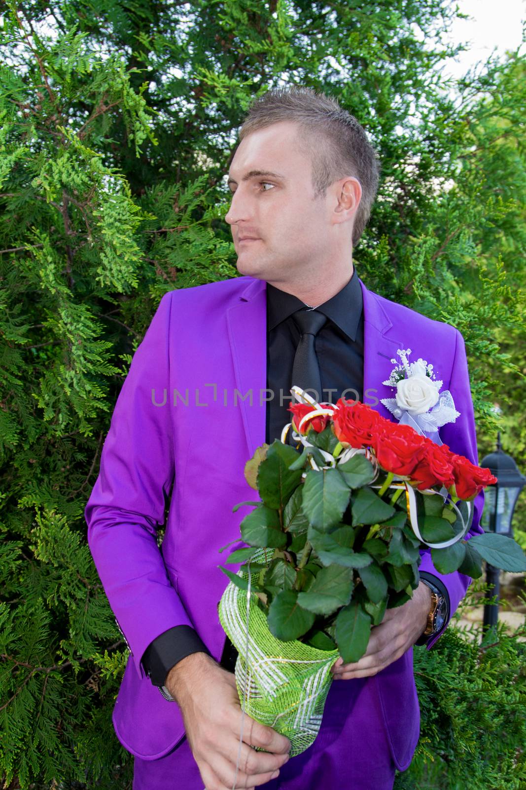 Young smiling man holding a bouquet of flowers. For your commercial and editorial use.