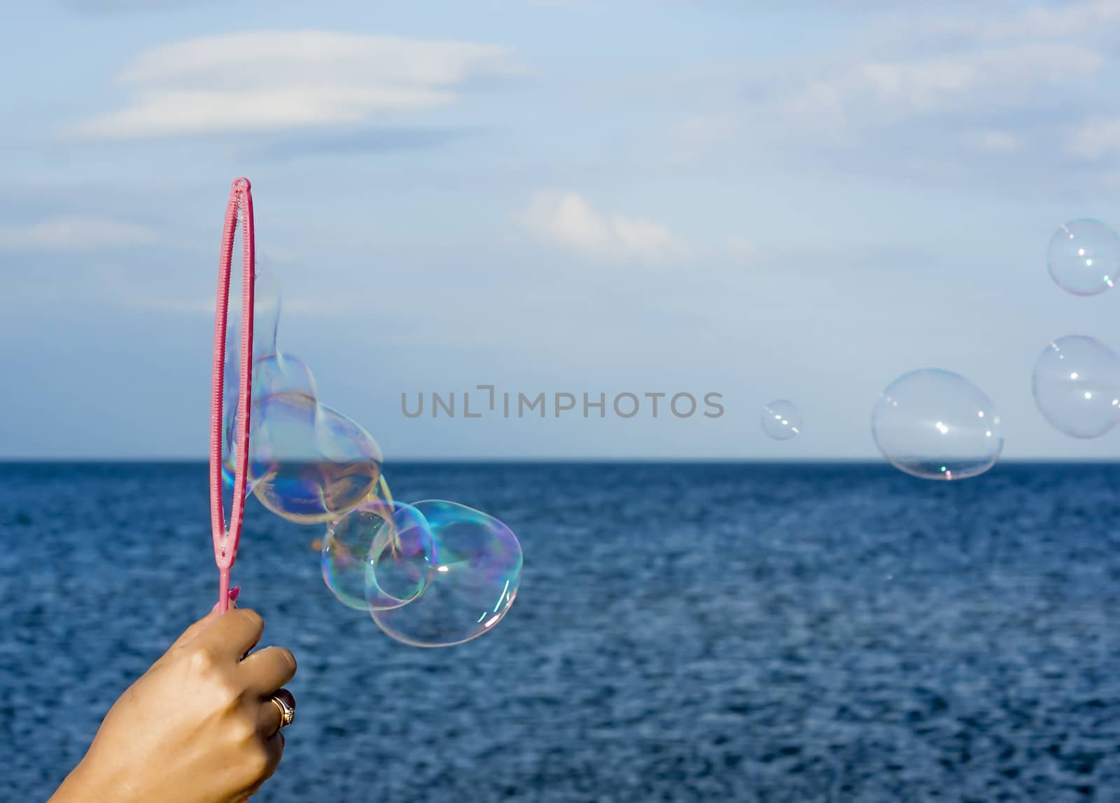 Colorful Soap Bubbles Against Blue Sky Background by serhii_lohvyniuk