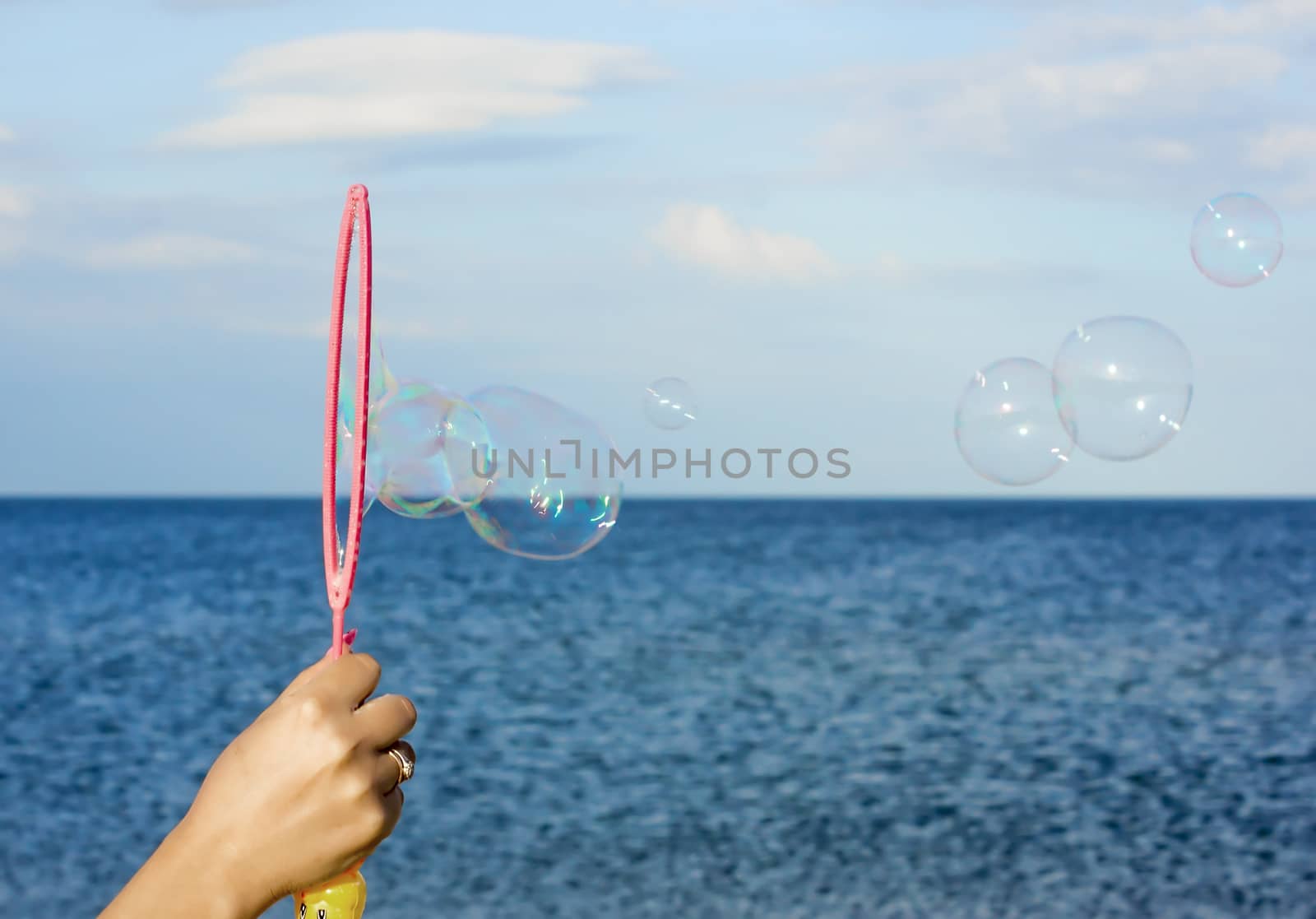 Colorful Soap Bubbles Against Blue Sky Background. For your commercial and editorial use.