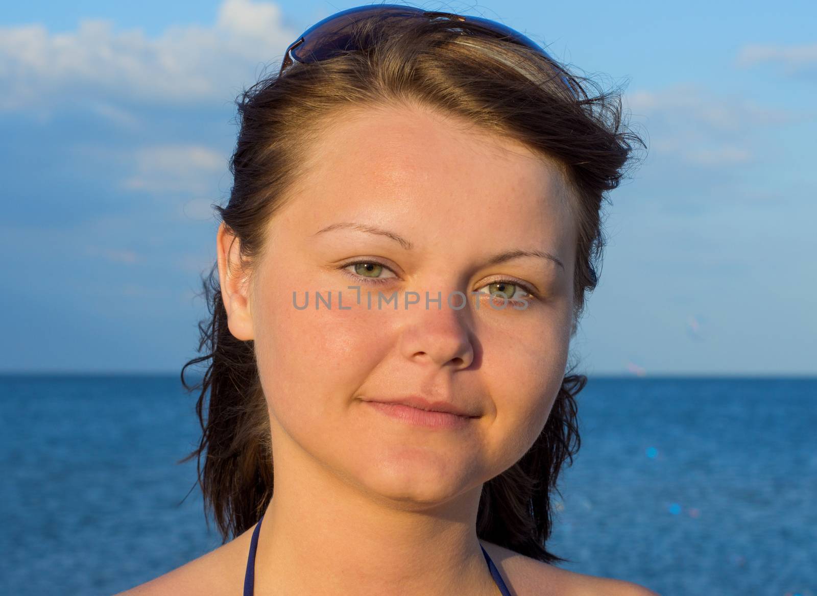 Portrait of a beautiful young woman on the beach with glasses.