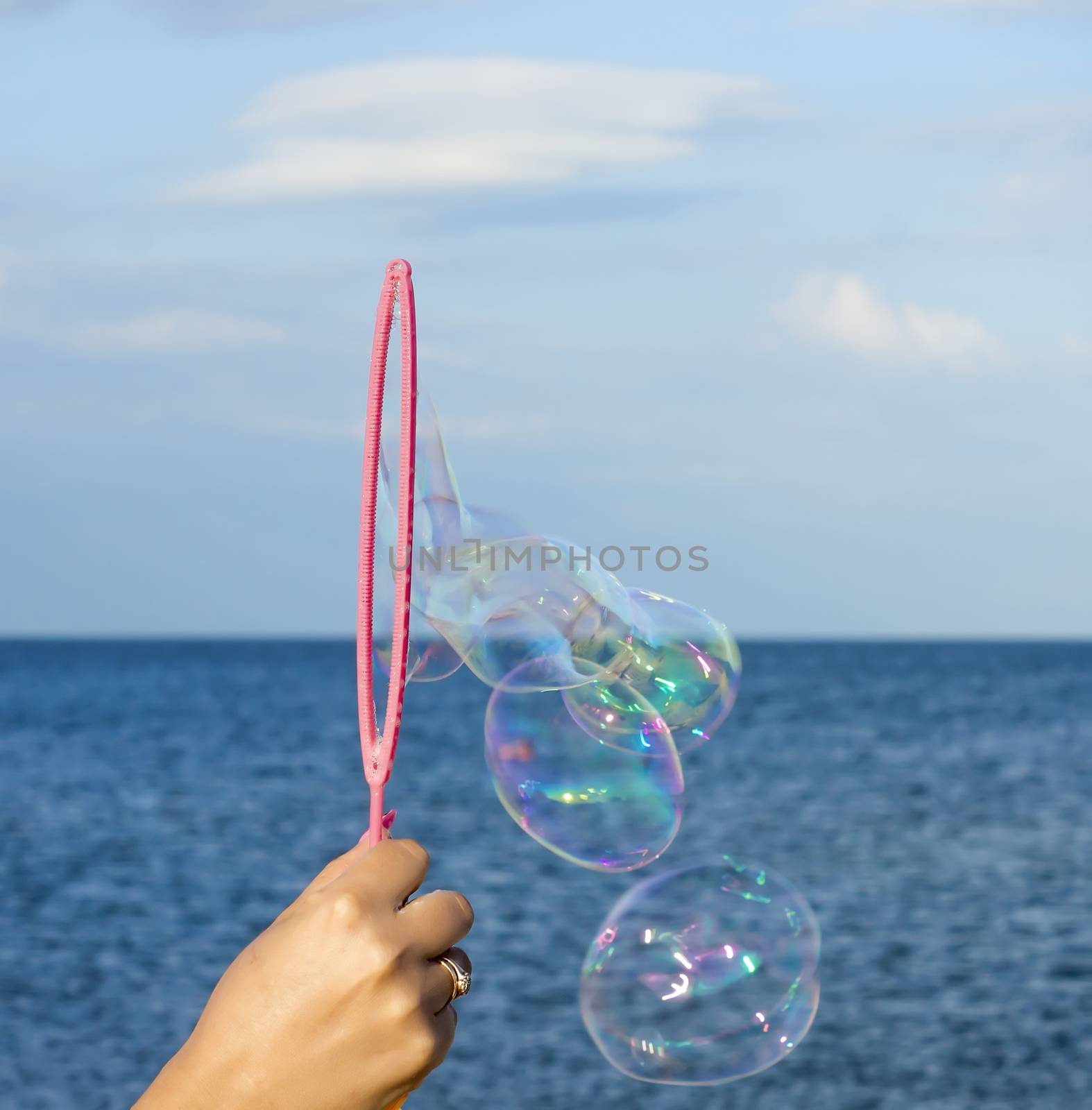 Colorful Soap Bubbles Against Blue Sky Background. For your commercial and editorial use.