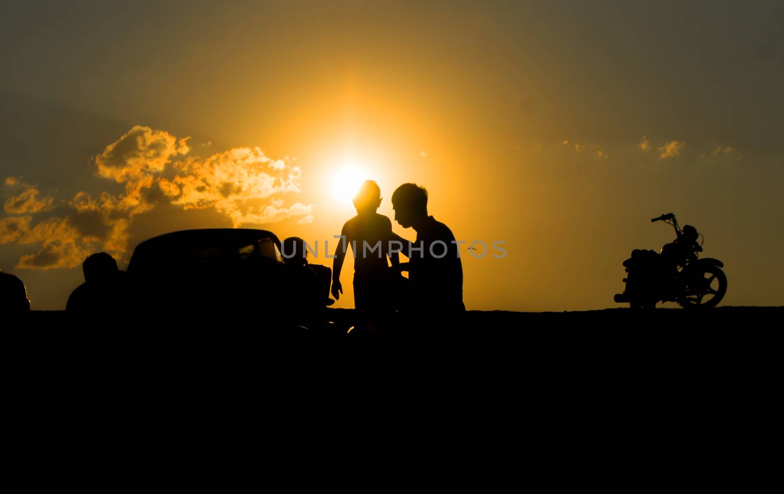 Silhouettes of father and child Motorcycle  against the suns by serhii_lohvyniuk