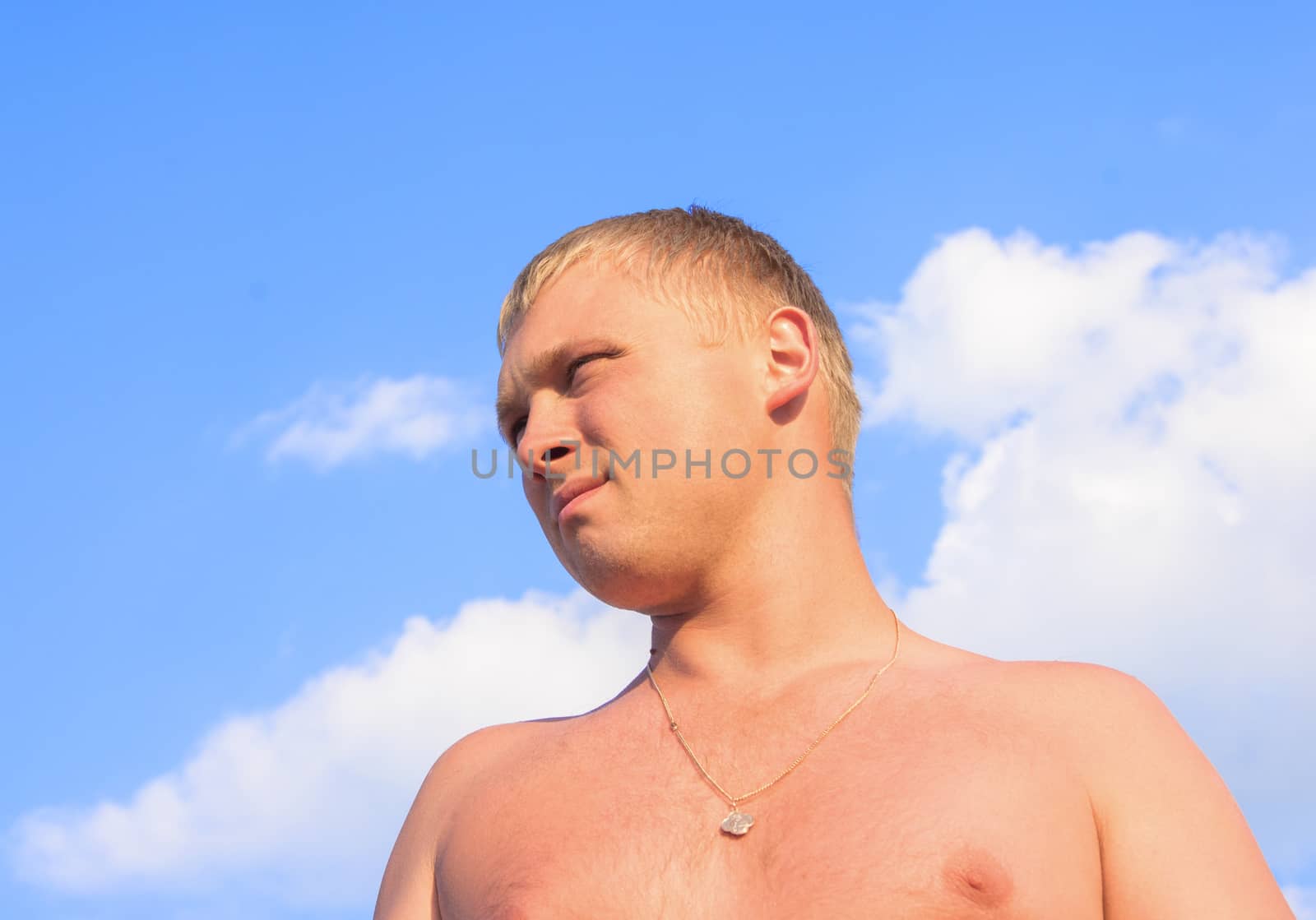 portrait of a young man on the beach looking into the distance.