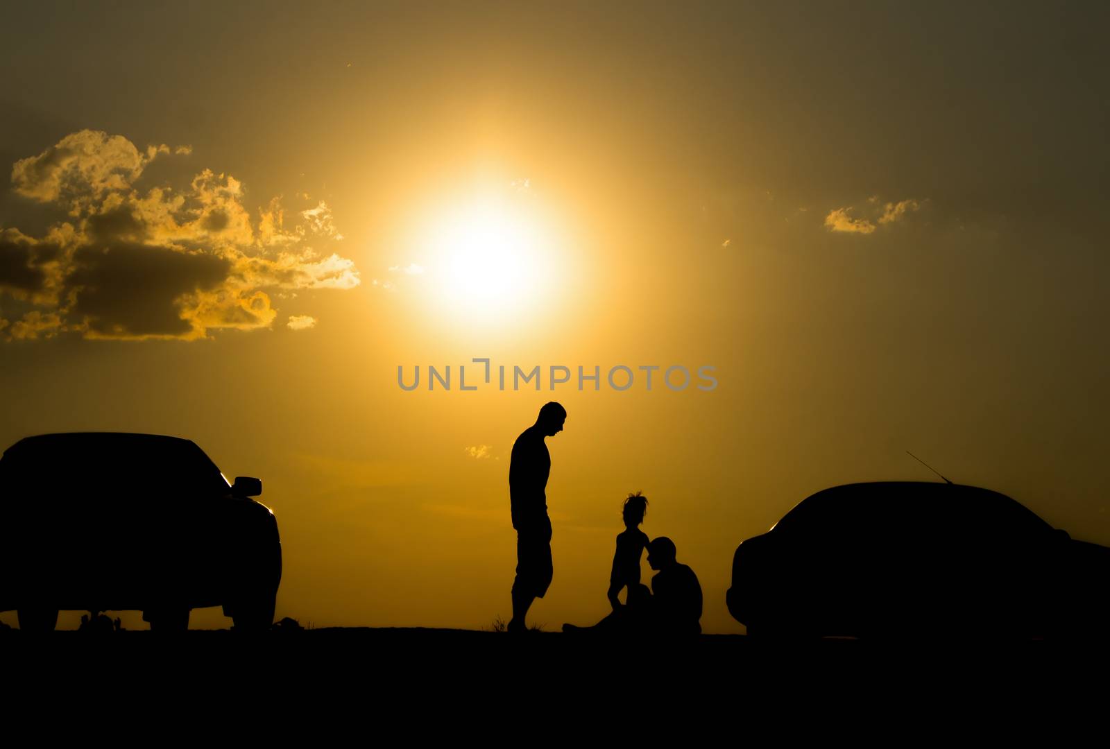 happy family of three people,celebrate outside at Sunset, Silhou by serhii_lohvyniuk