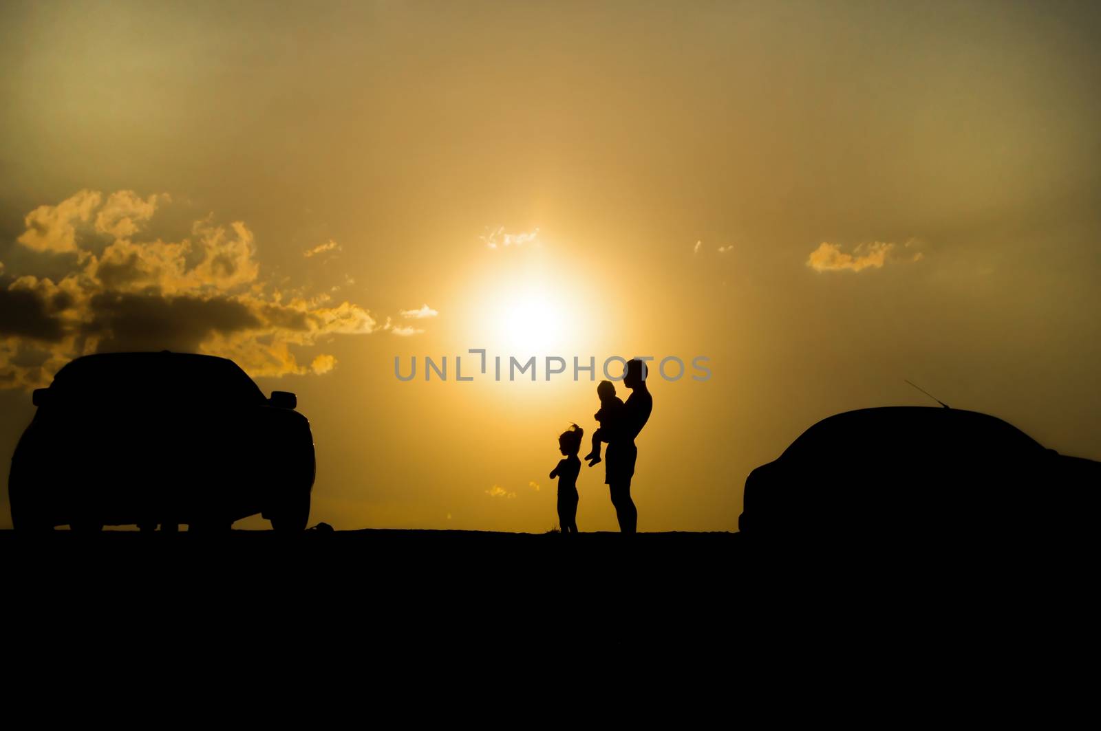 happy family of three people,celebrate outside at Sunset, Silhou by serhii_lohvyniuk