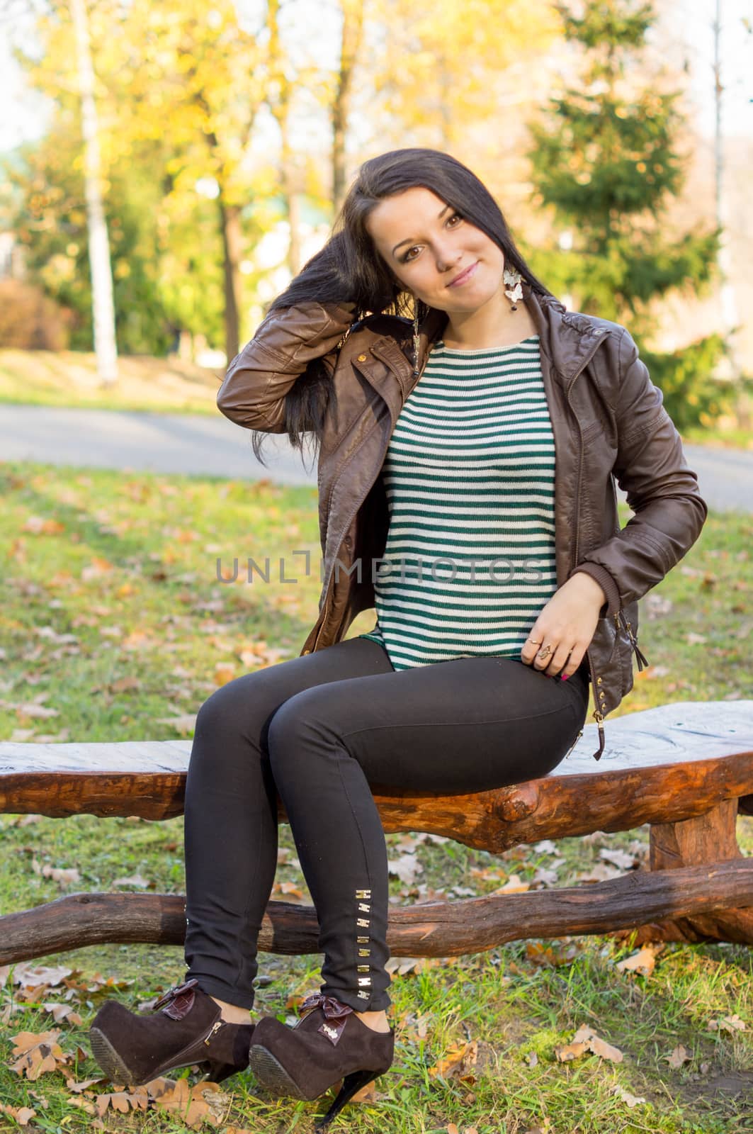 beautiful and sexy girl sitting on bench outdoors. 