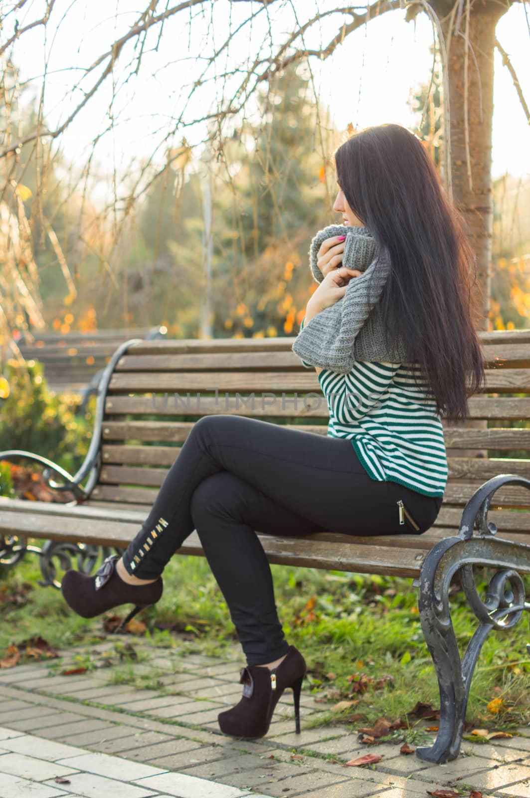 girl sitting on bench outdoors by serhii_lohvyniuk