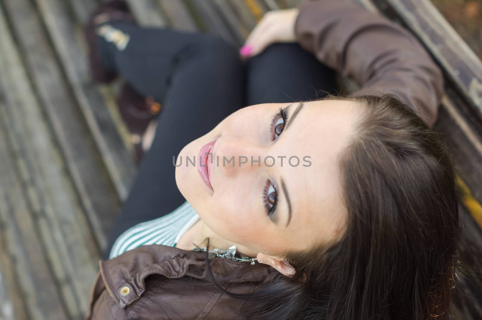 beautiful and sexy girl sitting on bench outdoors. 