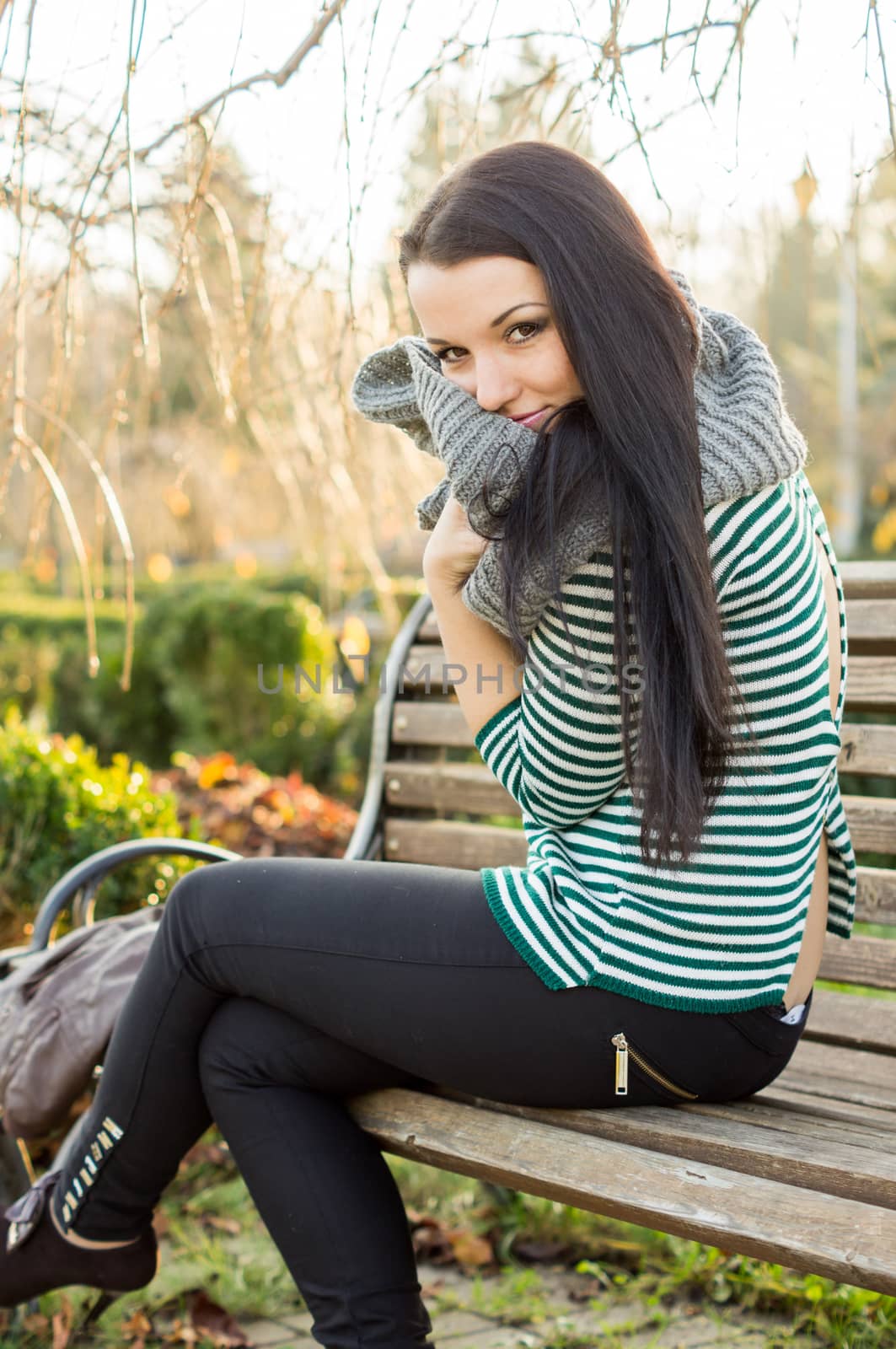 beautiful and sexy girl sitting on bench outdoors. 