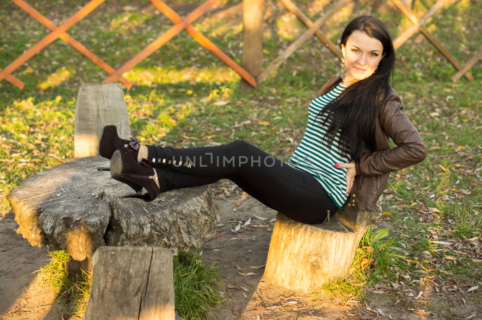 beautiful and sexy girl sitting on bench outdoors. 