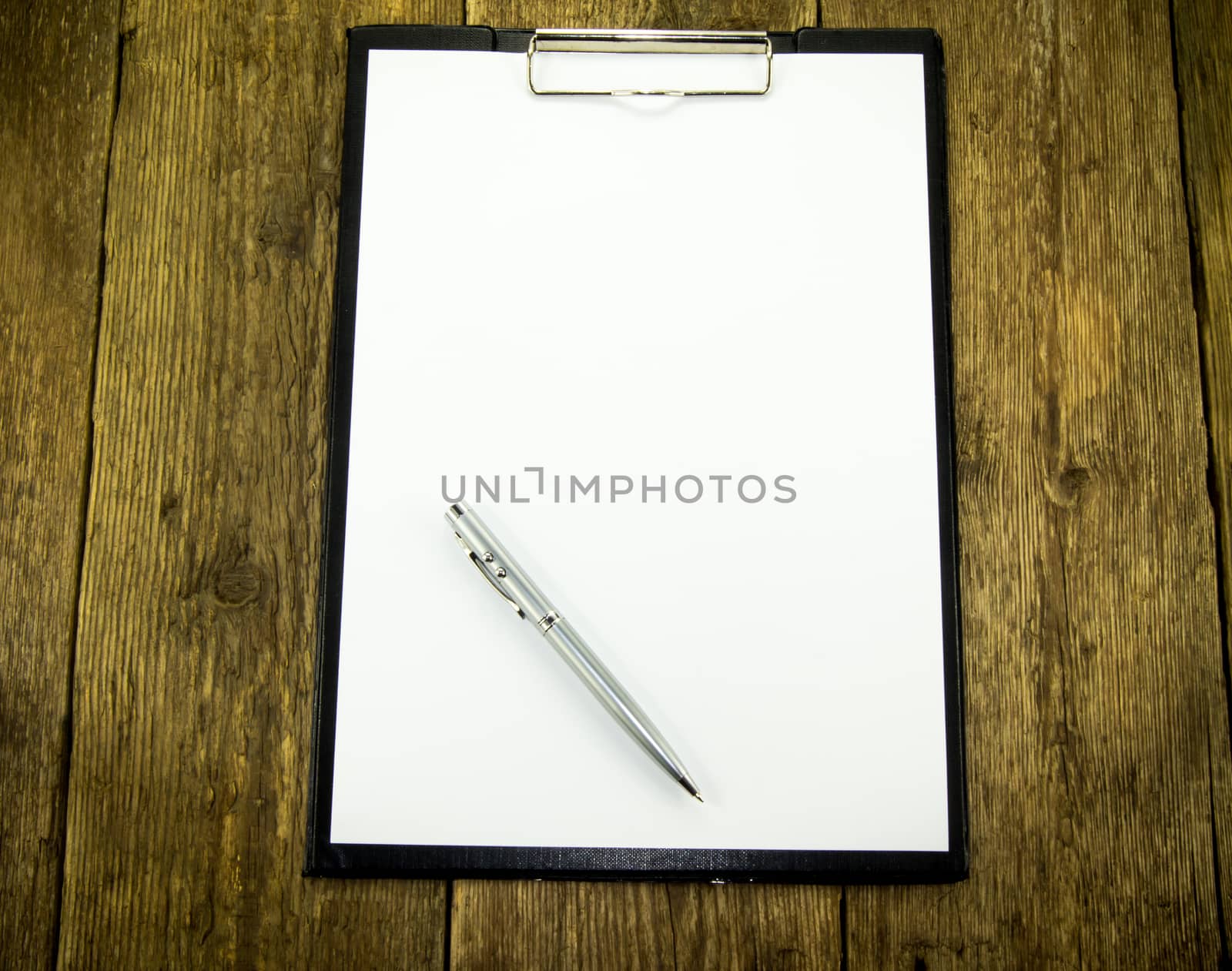 White paper and pen on wood background. For your commercial and editorial use