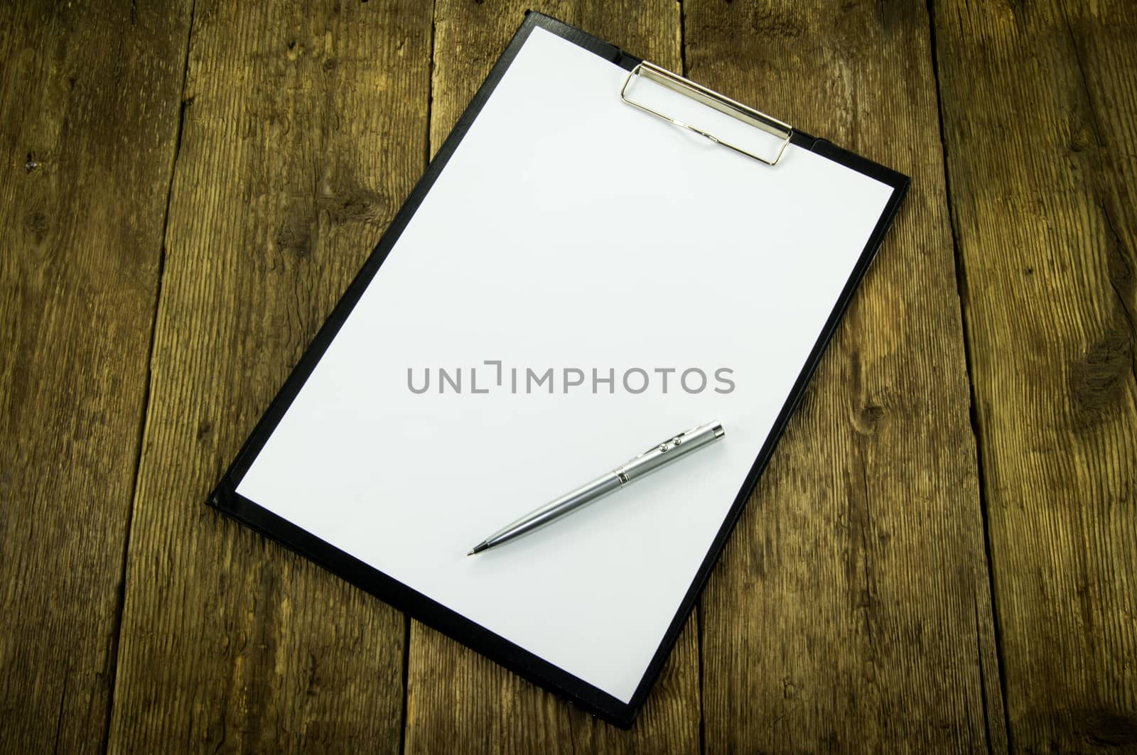 White paper and pen on wood background by serhii_lohvyniuk