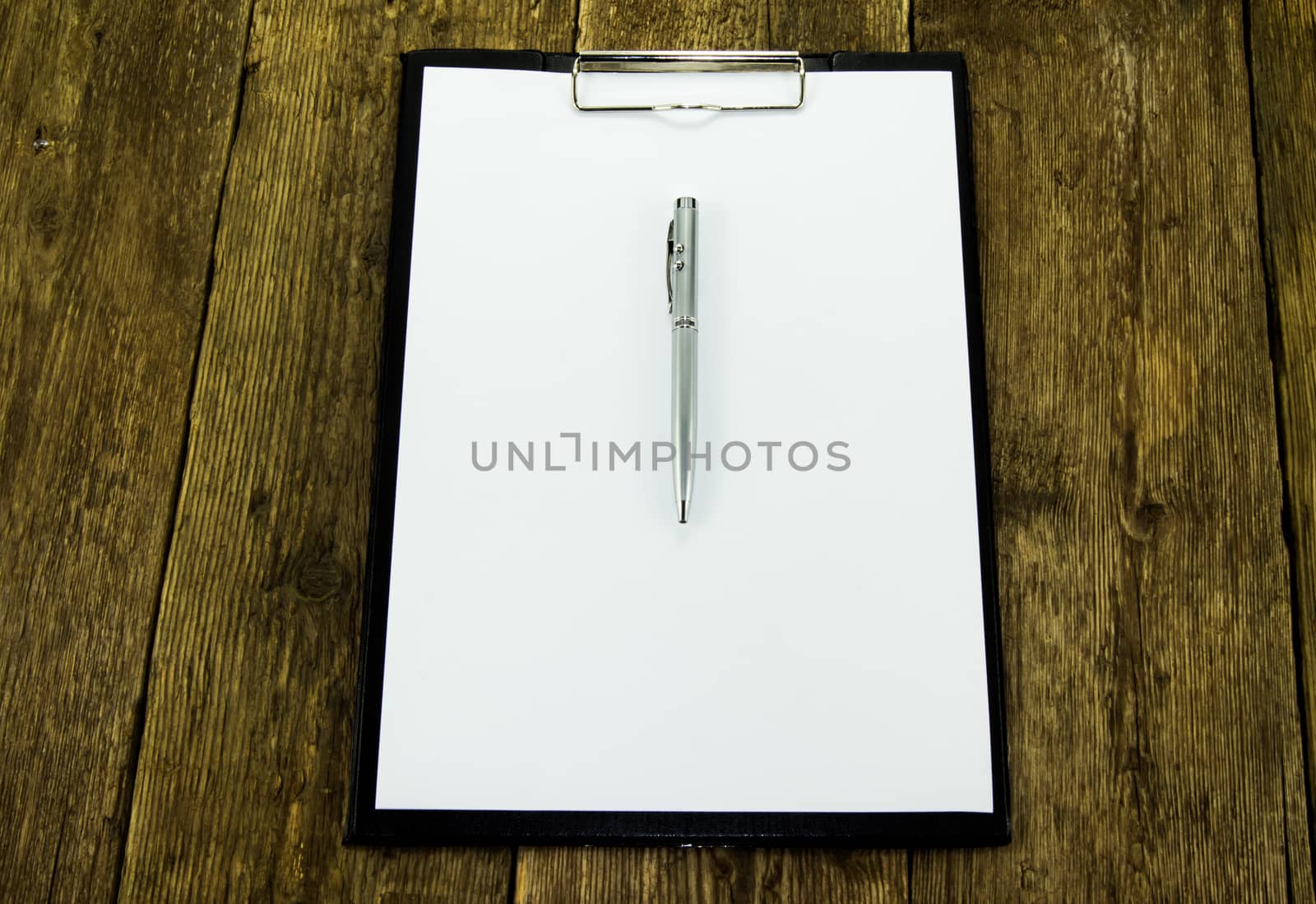 White paper and pen on wood background. For your commercial and editorial use