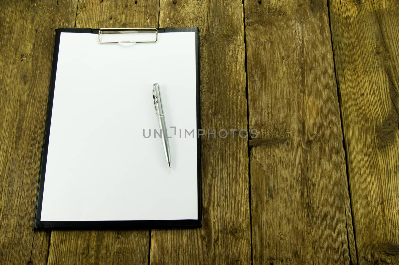White paper and pen on wood background by serhii_lohvyniuk