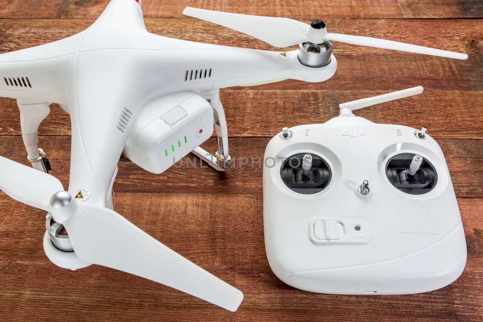 Fort Collins, CO, USA - March 17, 2015:  DJI Phantom 2 quadcopter drone with a radio controller against rustic wooden wood table