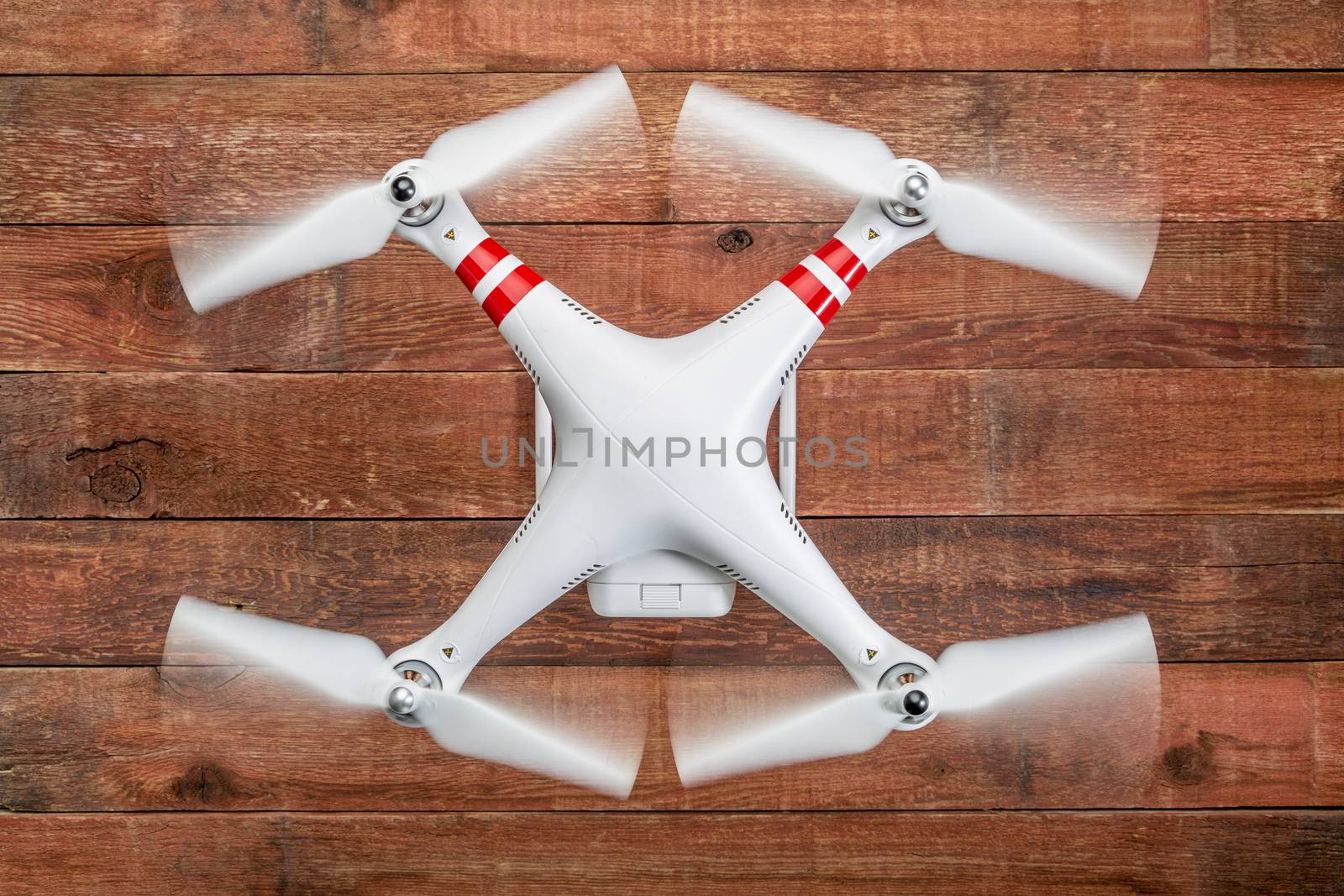 Fort Collins, CO, USA - March 17, 2015:  DJI Phantom 2 with spinning propellers, top view against rustic wooden wood table