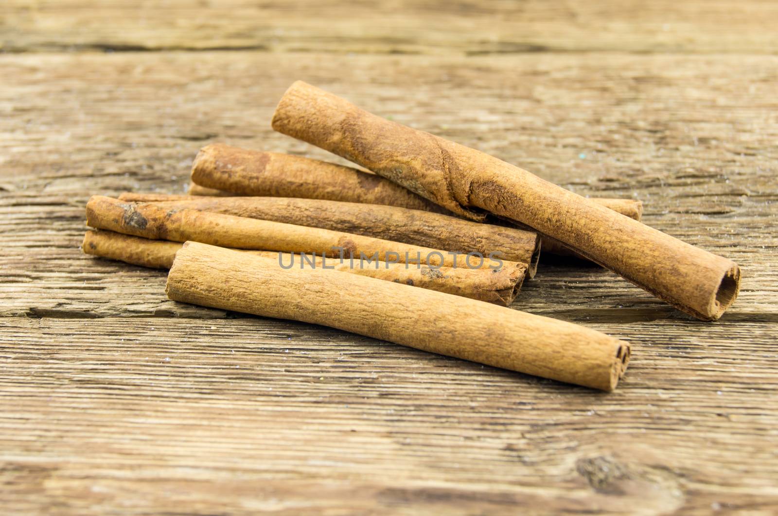 Close up of cinnamon sticks on rustic wood  by serhii_lohvyniuk
