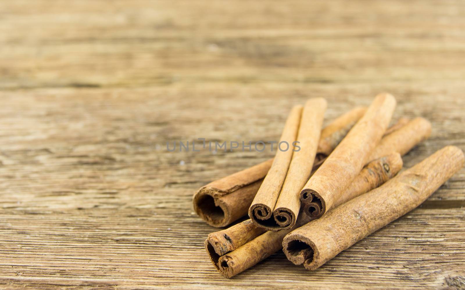 Close up of cinnamon sticks on rustic wood . For your commercial and editorial use.