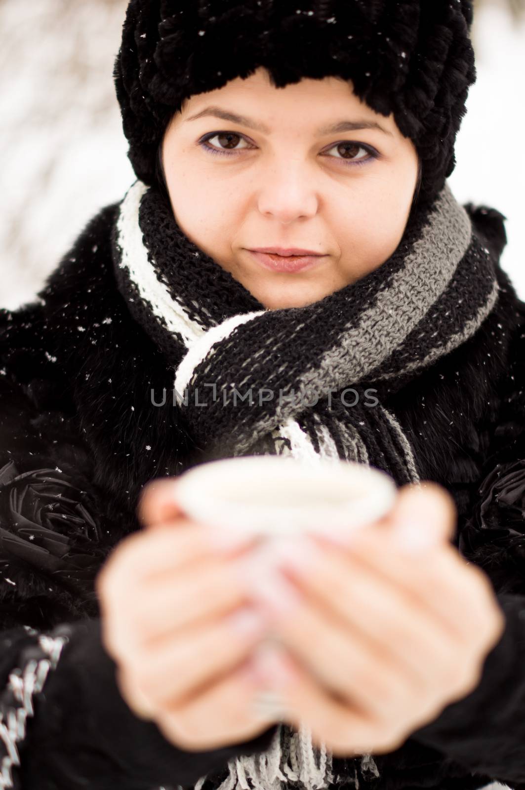 woman with cup of coffee in the winter park by serhii_lohvyniuk