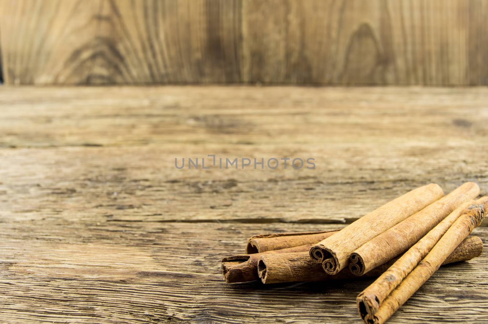 Close up of cinnamon sticks on rustic wood  by serhii_lohvyniuk
