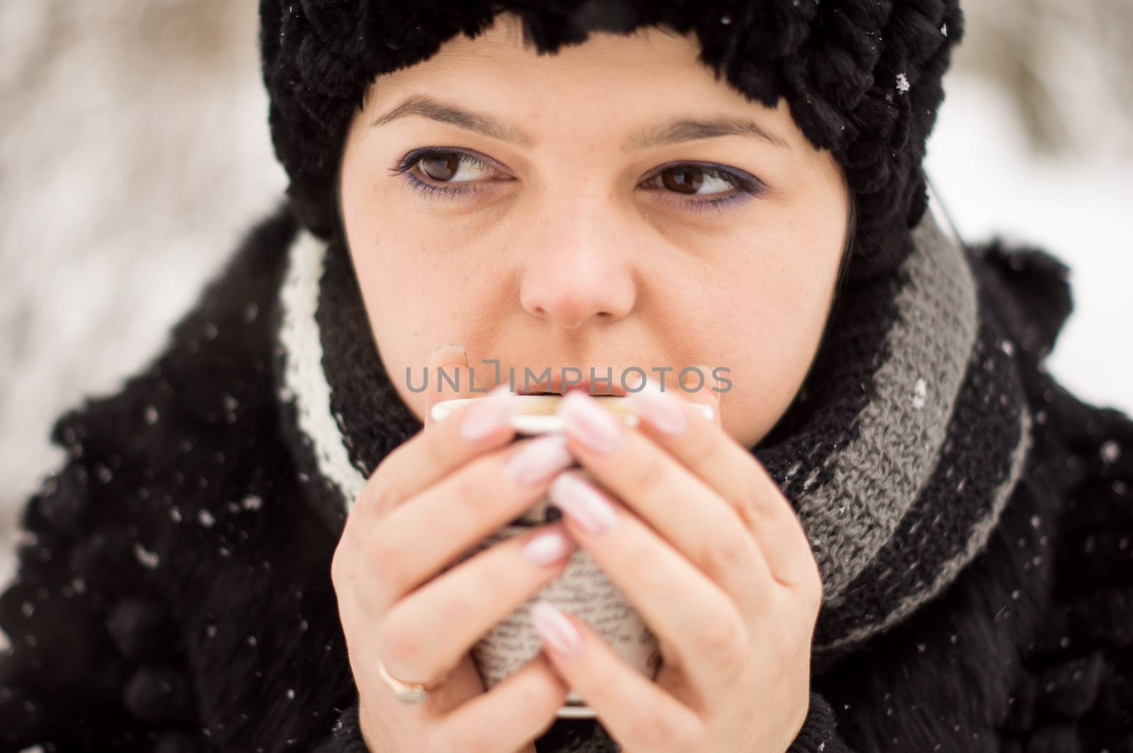 woman with cup of coffee in the winter park by serhii_lohvyniuk