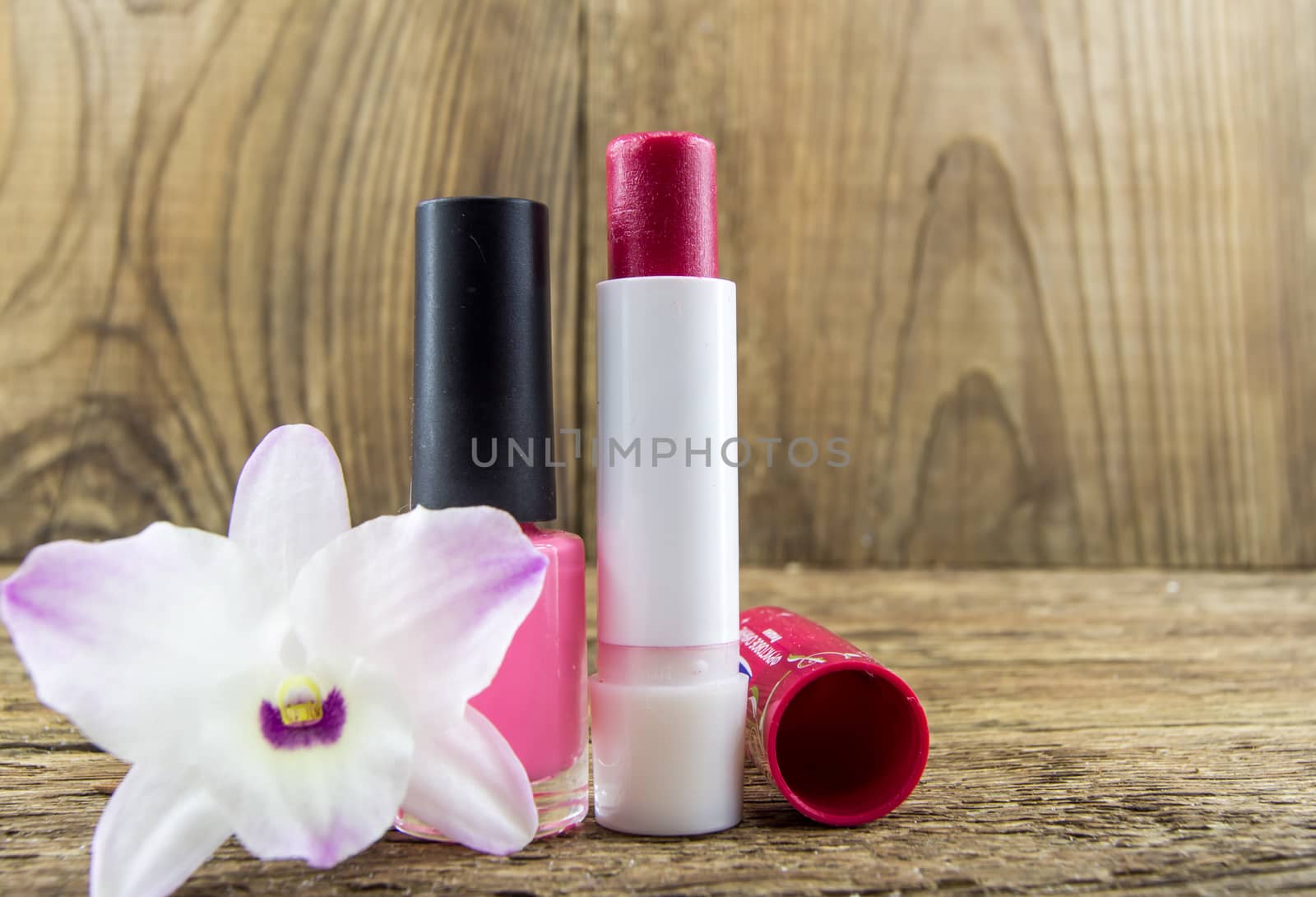 cosmetics and flowers on table on wooden background