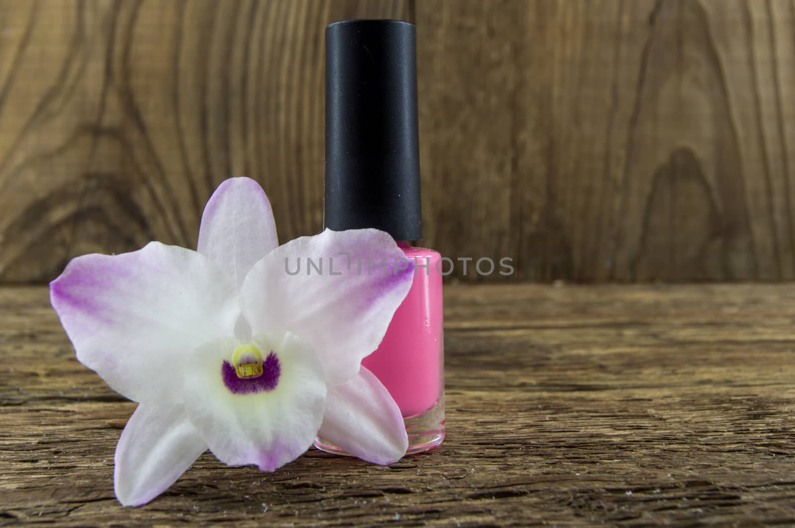 cosmetics and flowers on table on wooden background