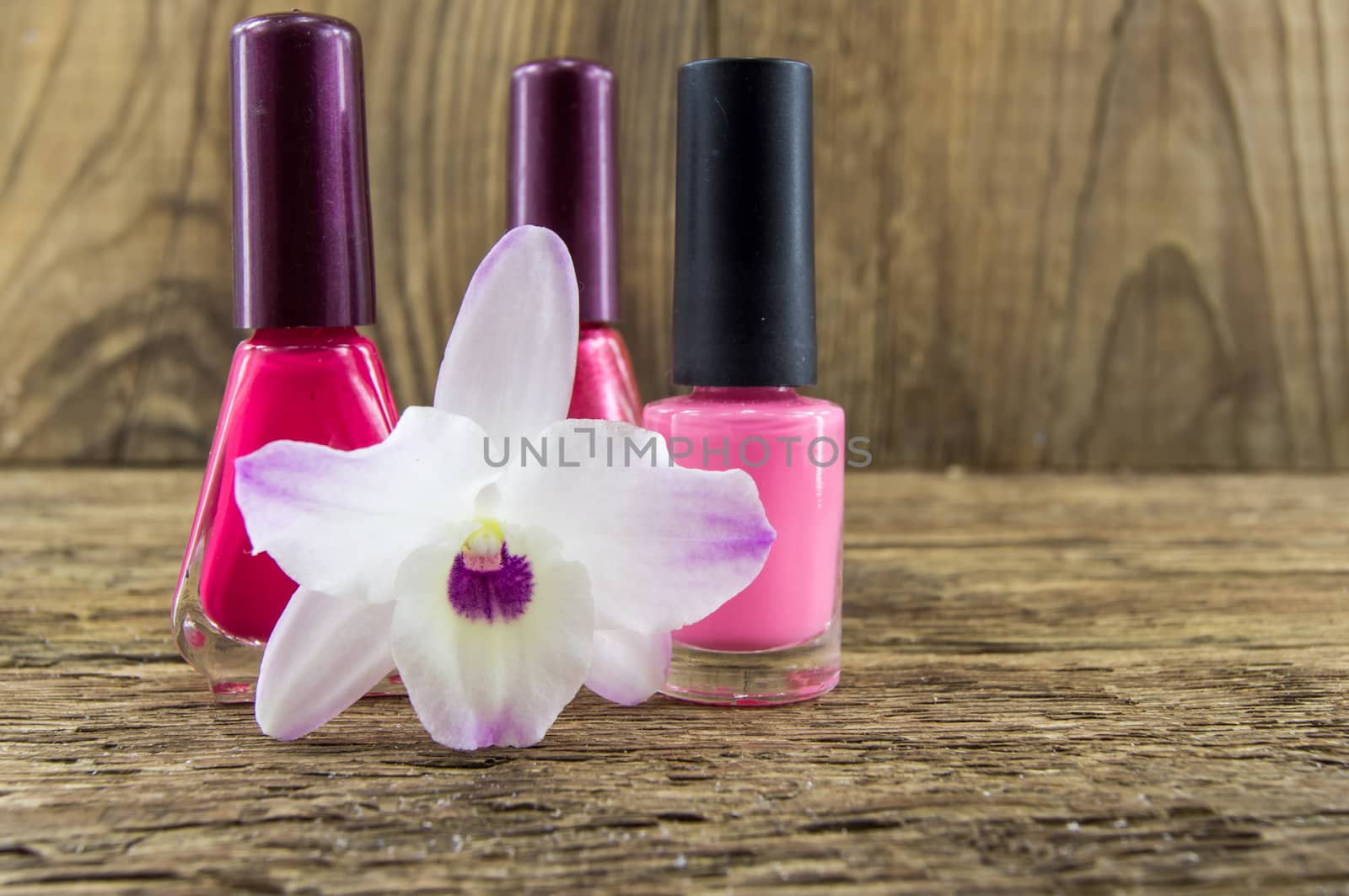 cosmetics and flowers on table on wooden background