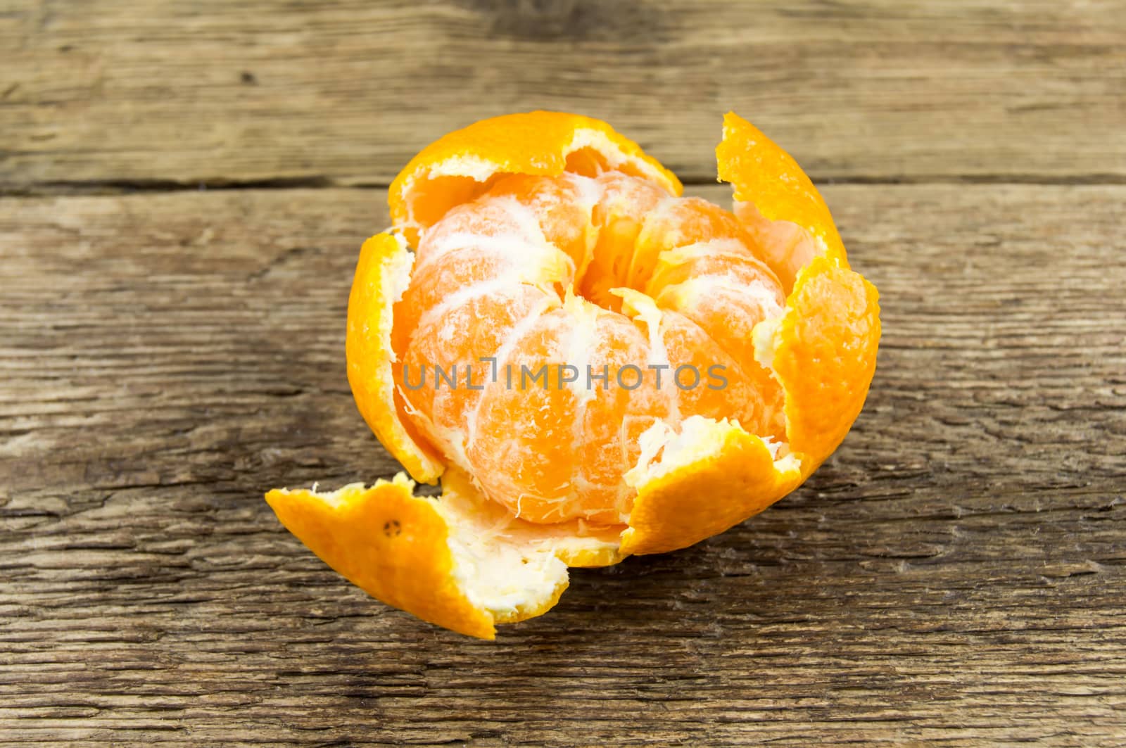 Ripe tangerines lie on a wooden background.