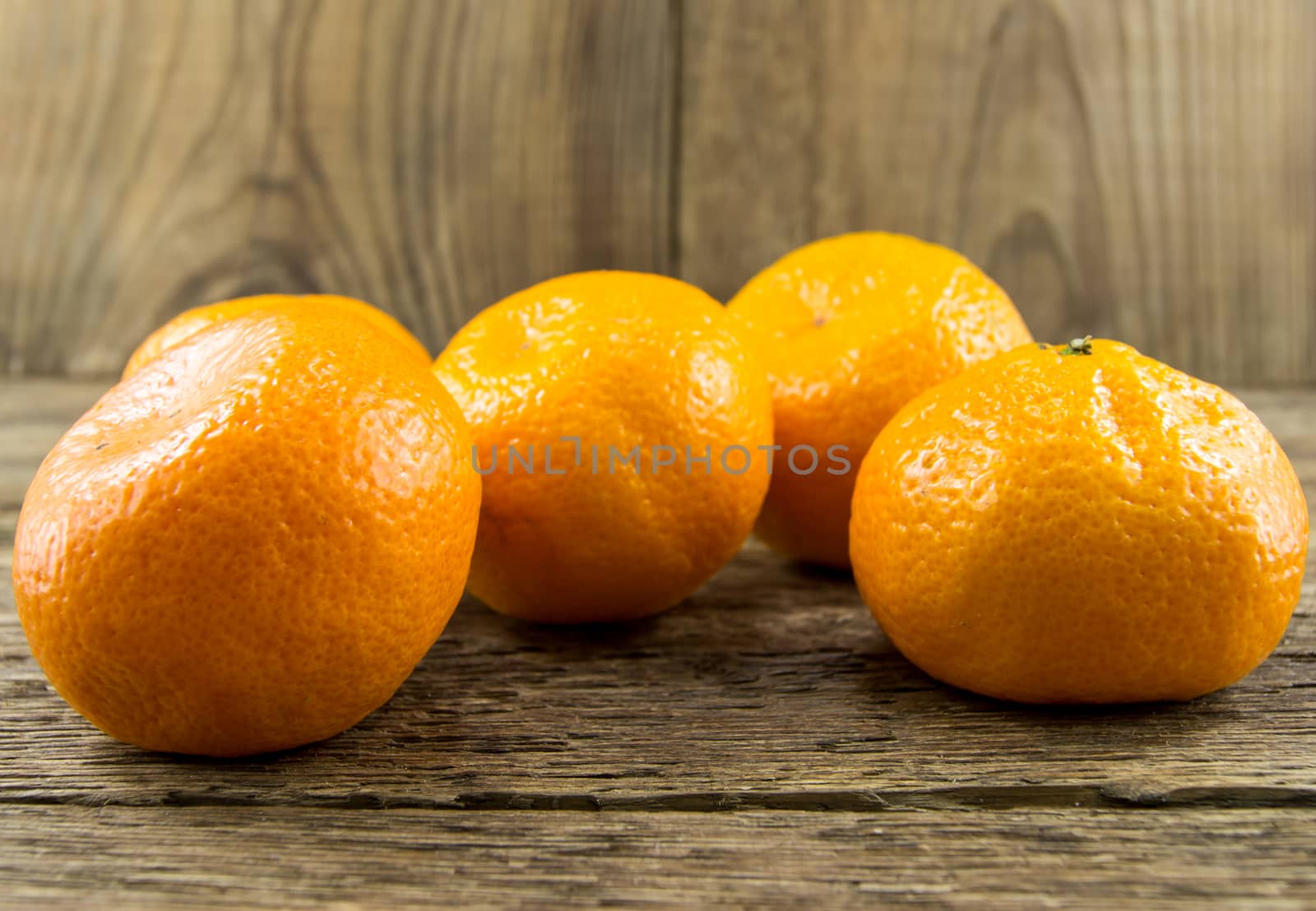 Ripe tangerines lie on a wooden background