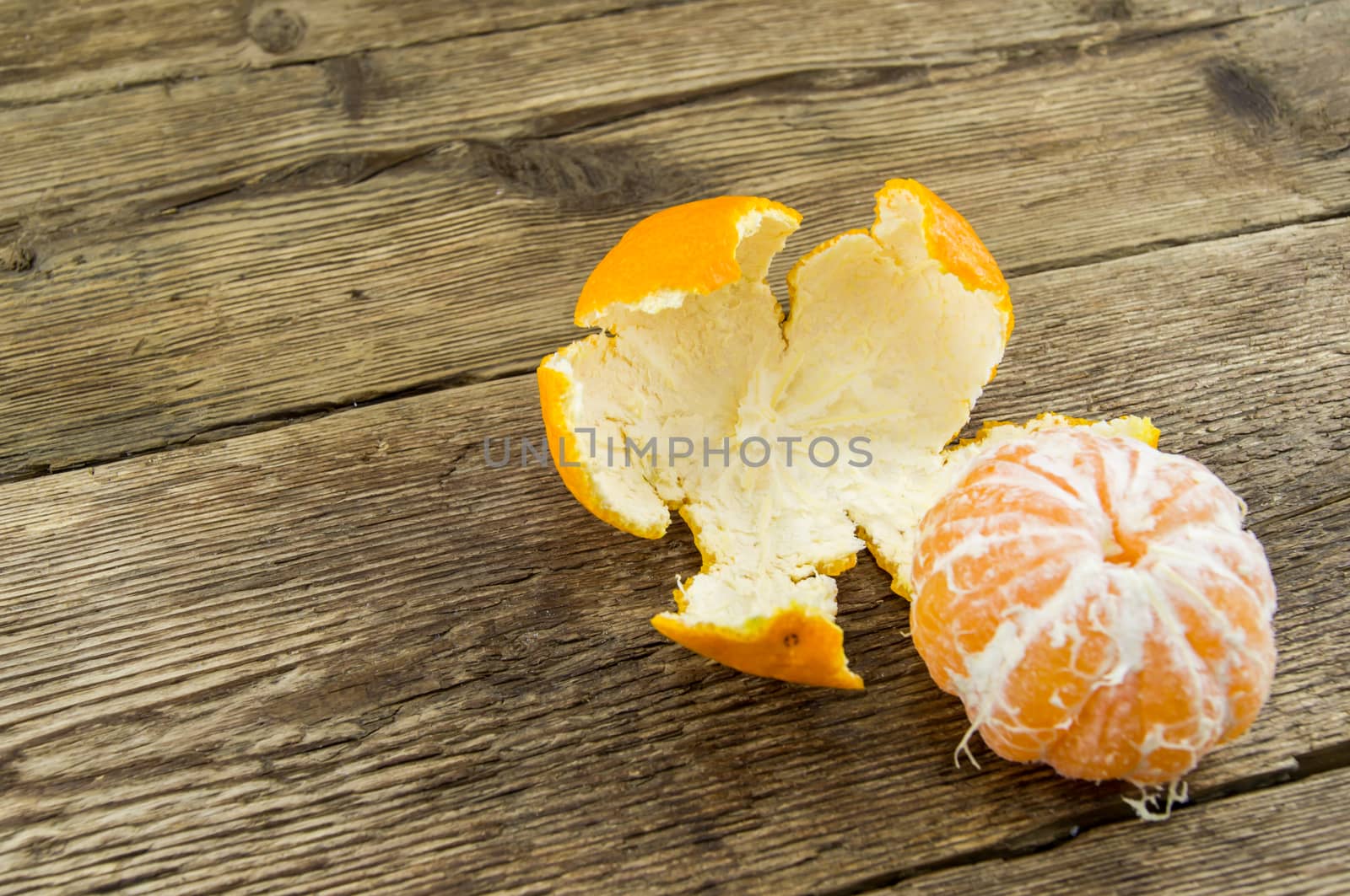 Ripe tangerines lie on a wooden background.