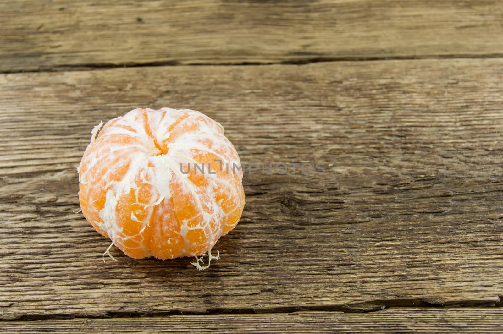 Ripe tangerines lie on a wooden background.