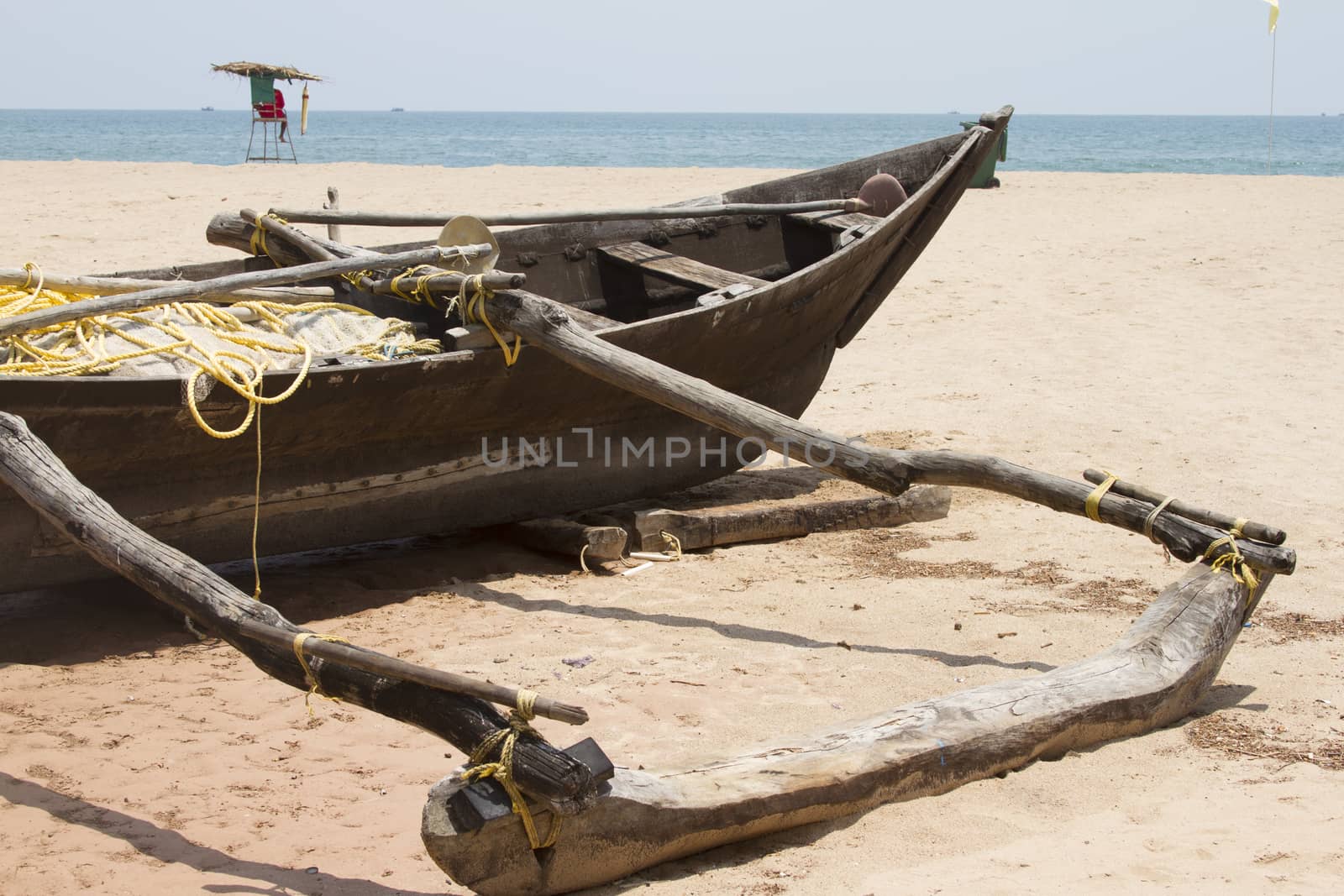 Old fishing boat standing on the sandy beach. India, Goa.