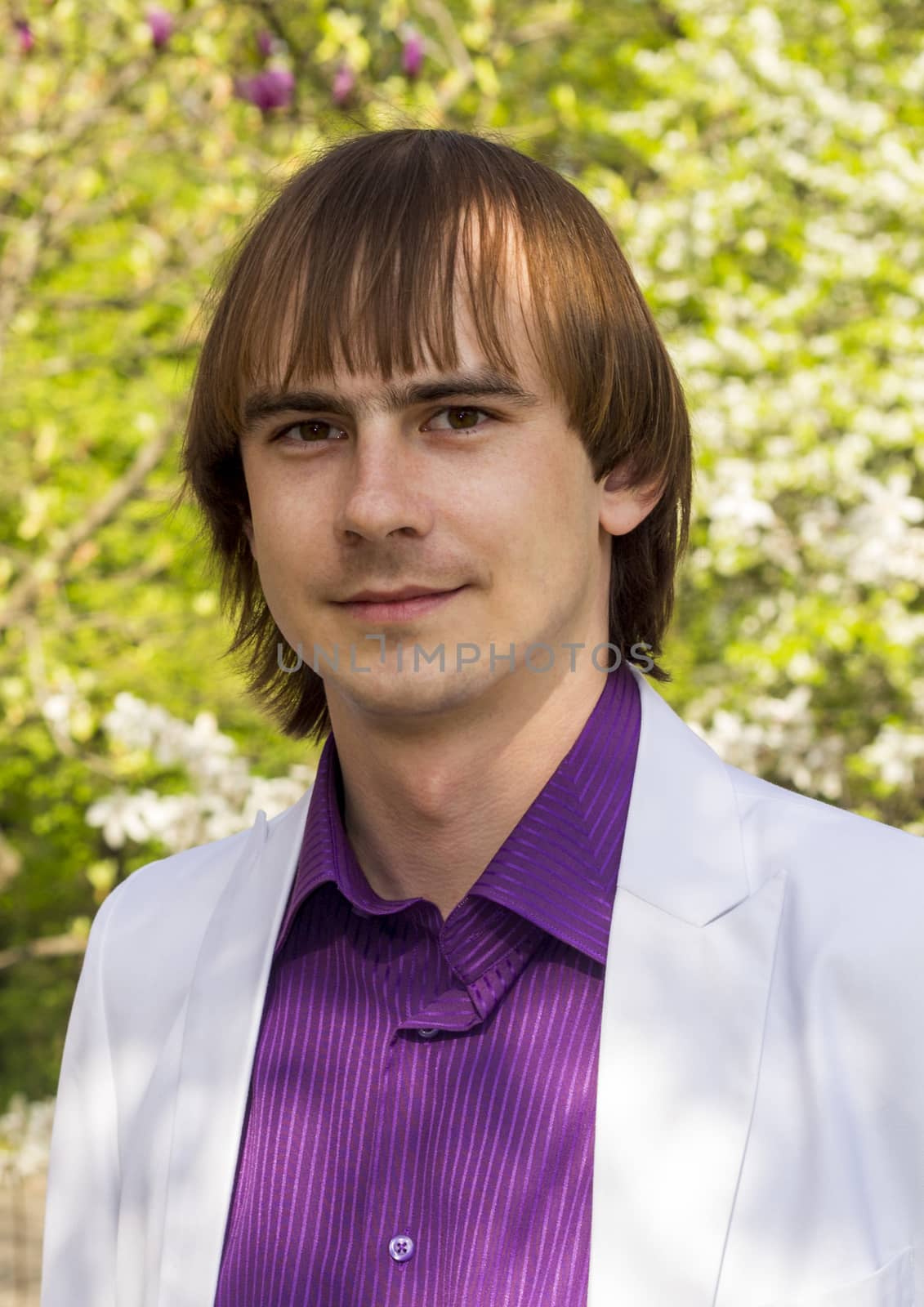 happy guy in the park a white suit and purple shirt by serhii_lohvyniuk