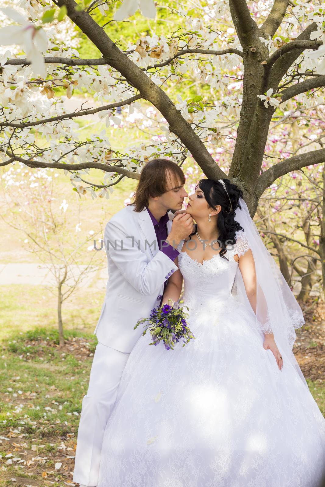Bride and groom with a bouquet of kisses on the nature by serhii_lohvyniuk
