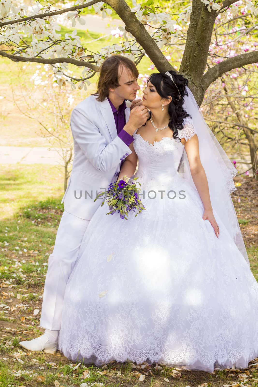 Bride and groom with a bouquet of kisses on the nature.