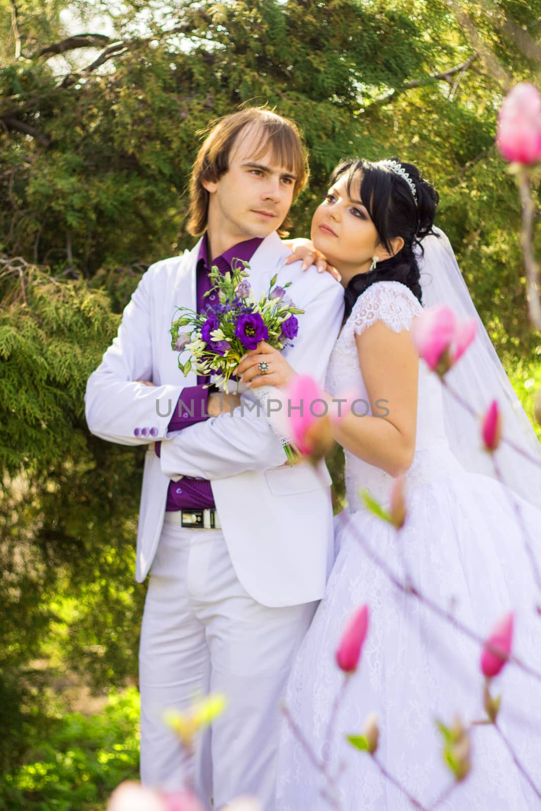 Elegant bride and groom posing together outdoors on a wedding day