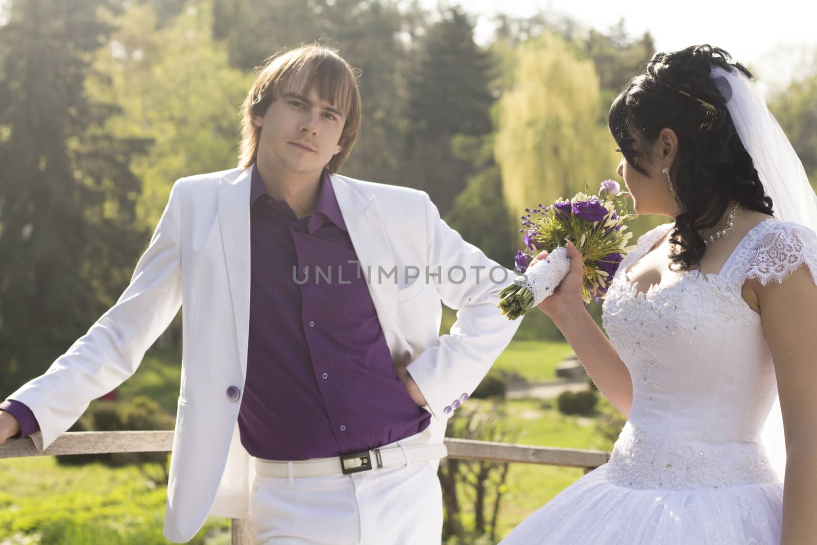 Elegant bride and groom posing together outdoors on a wedding da by serhii_lohvyniuk