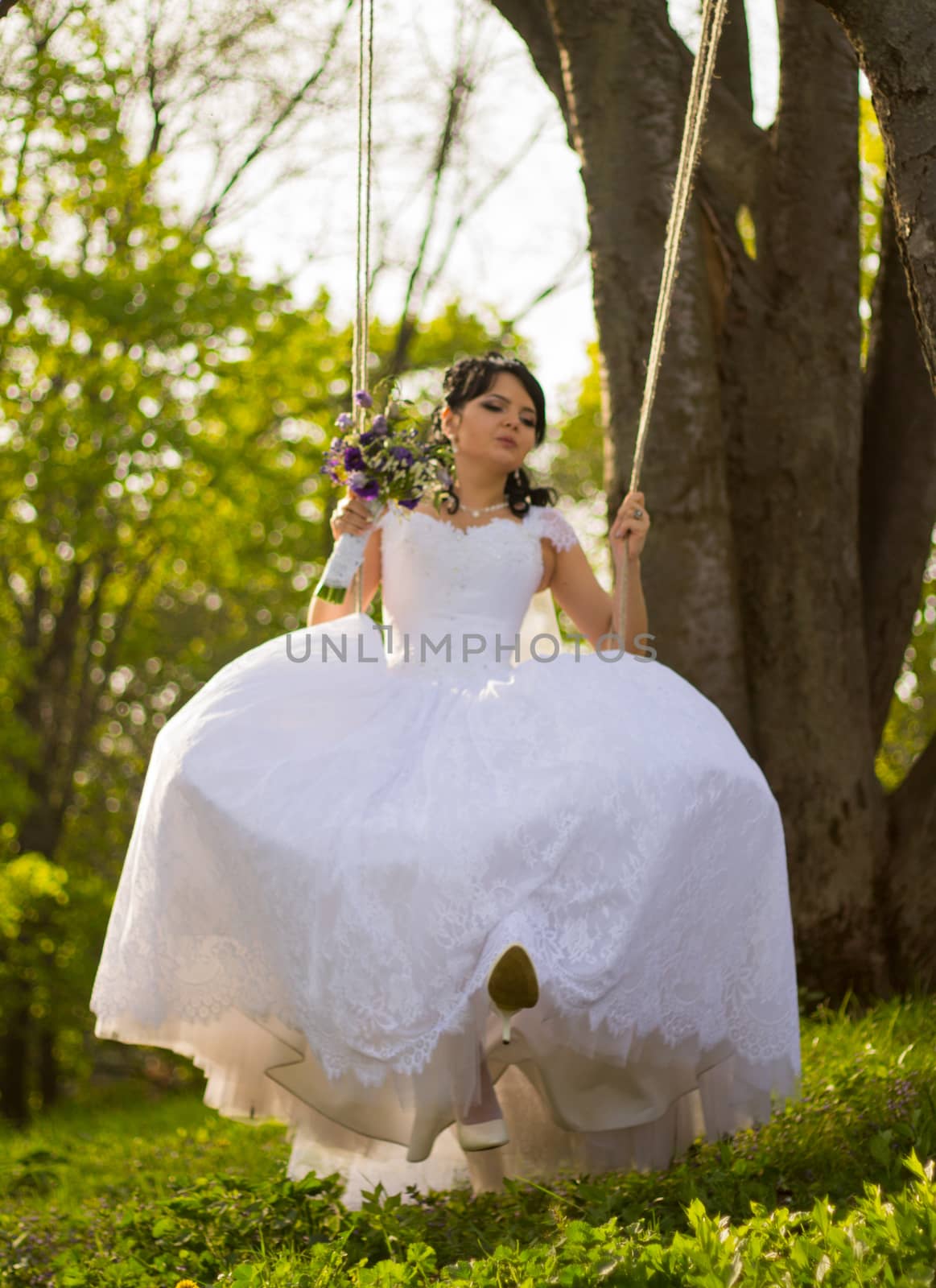 Portrait of a beautiful bride in white wedding dress sitting on  by serhii_lohvyniuk