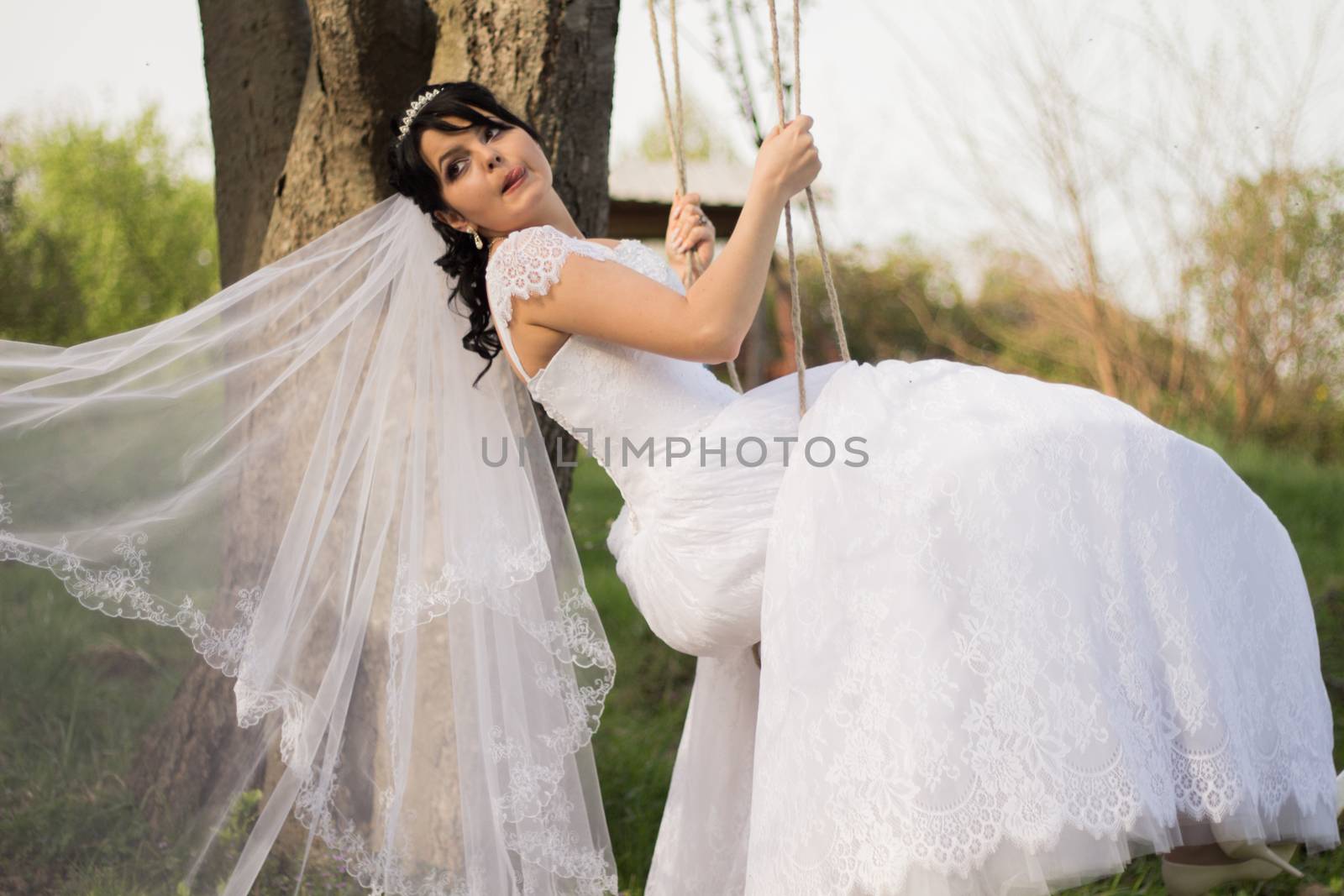 Portrait of a beautiful bride in white wedding dress sitting on  by serhii_lohvyniuk