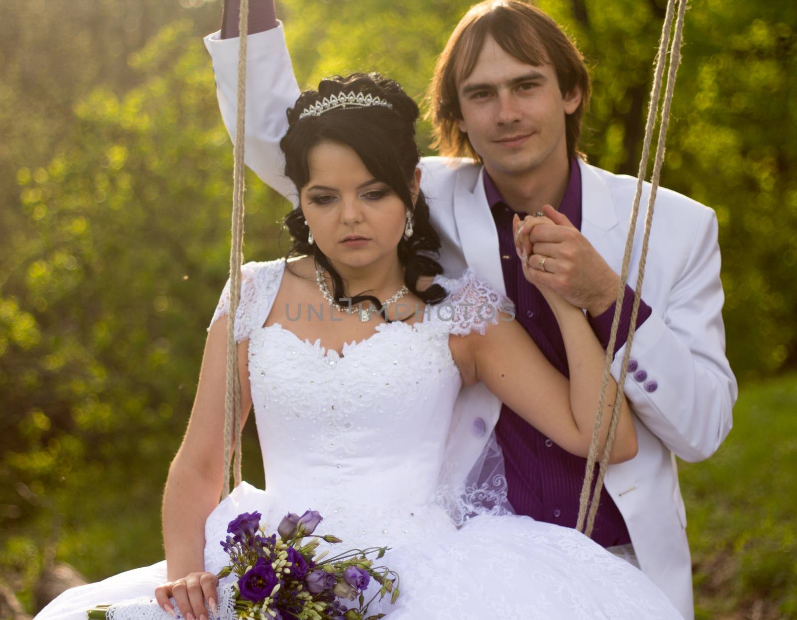 bride and groom swinging on a swing by serhii_lohvyniuk
