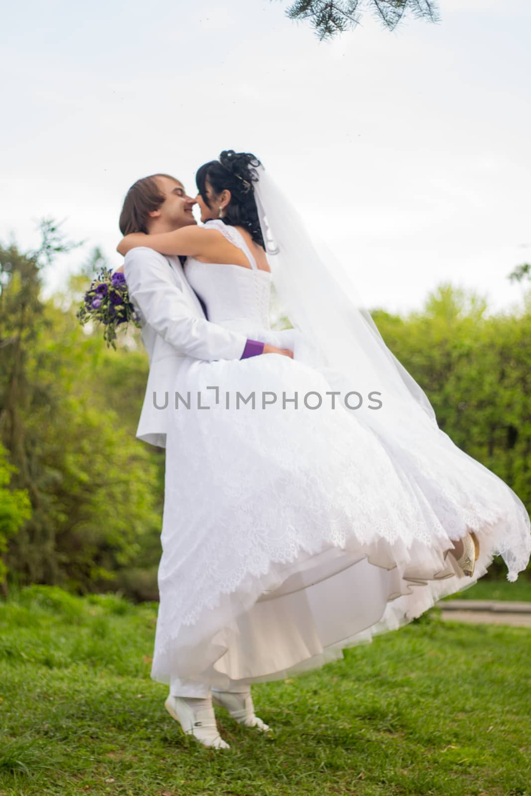 Groom and Bride in a park. wedding dress. Bridal wedding bouquet of flowers