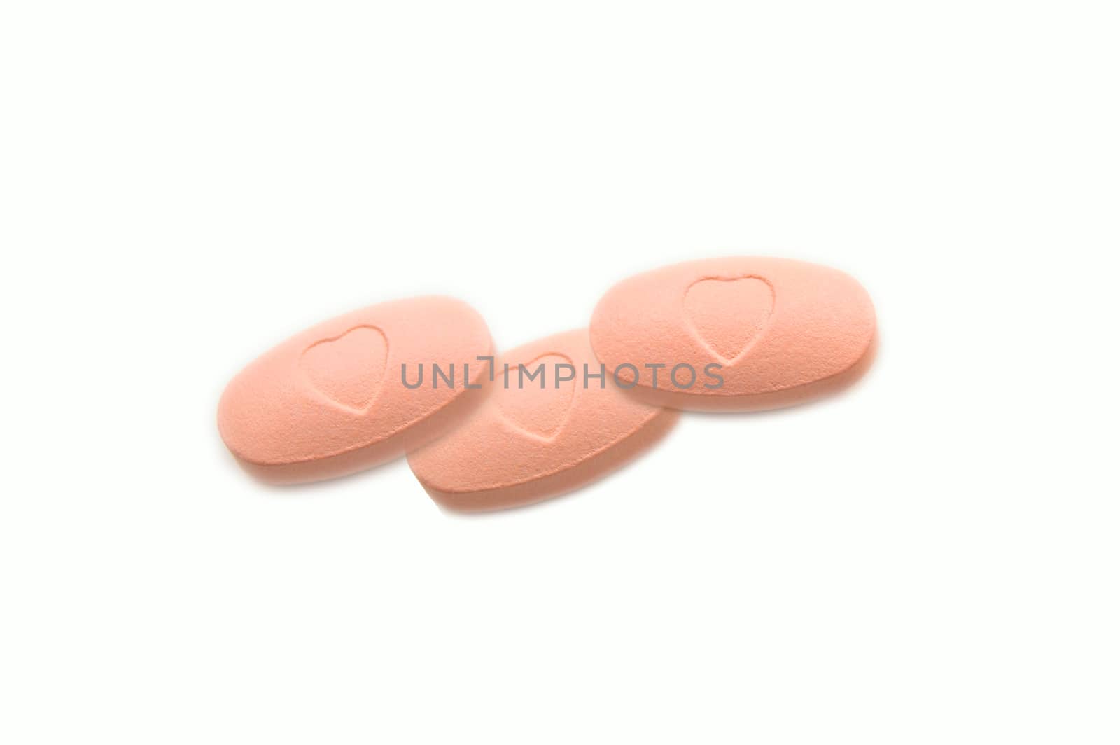 Pink tablets isolated on white background
