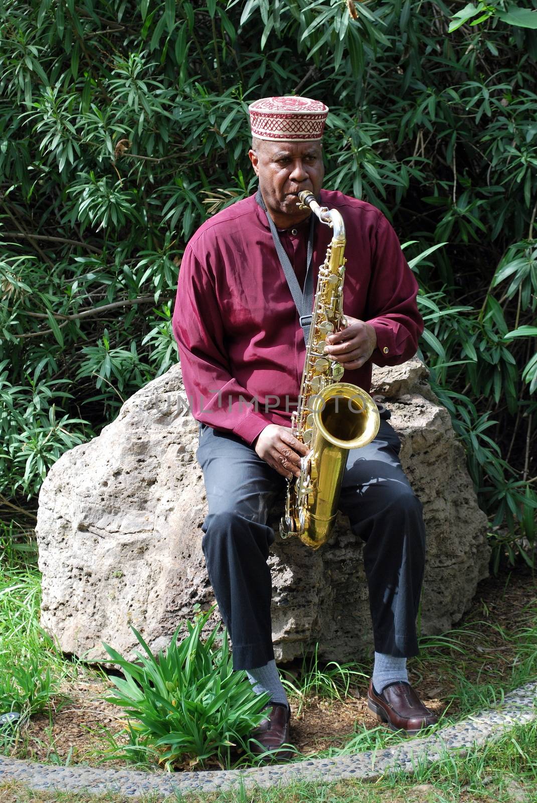 Muslim jazz musician with his saxophone outside.