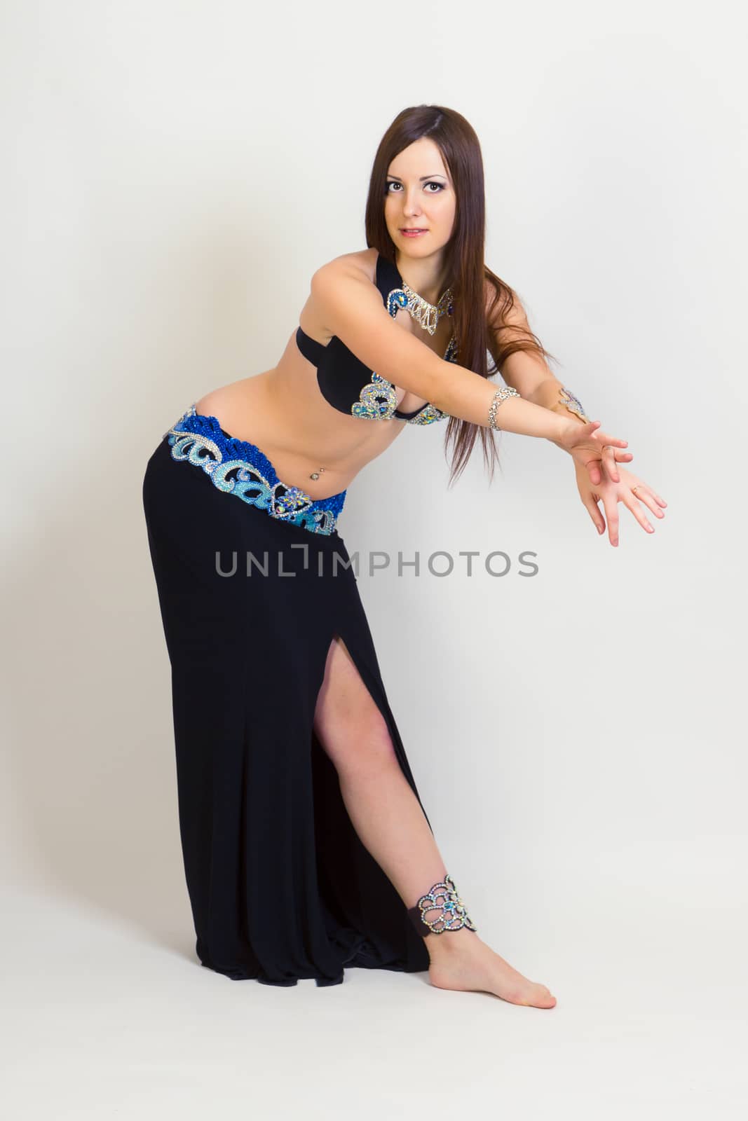 young woman dressed as a performing belly dancing. Studio. full height