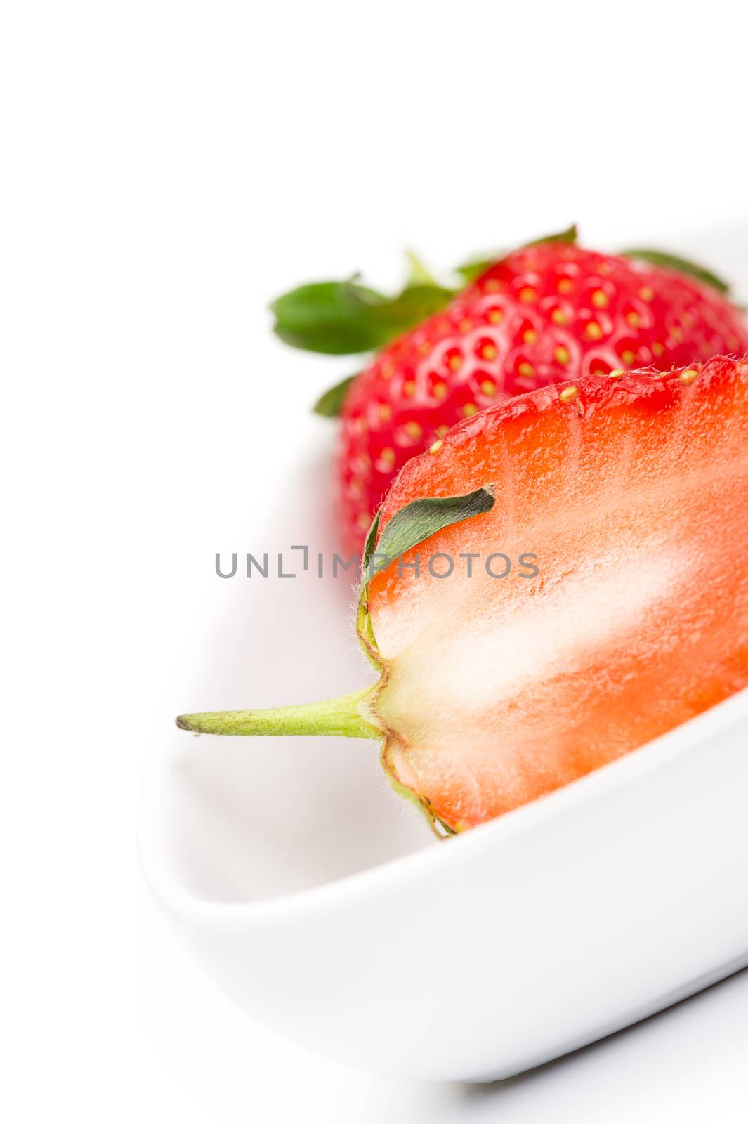 Closeup of a halved fresh ripe strawberry by MOELLERTHOMSEN