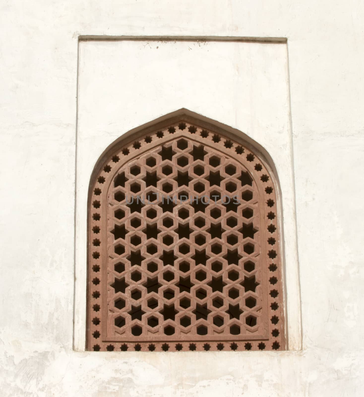 Old window with a lattice on a white wall by mcherevan