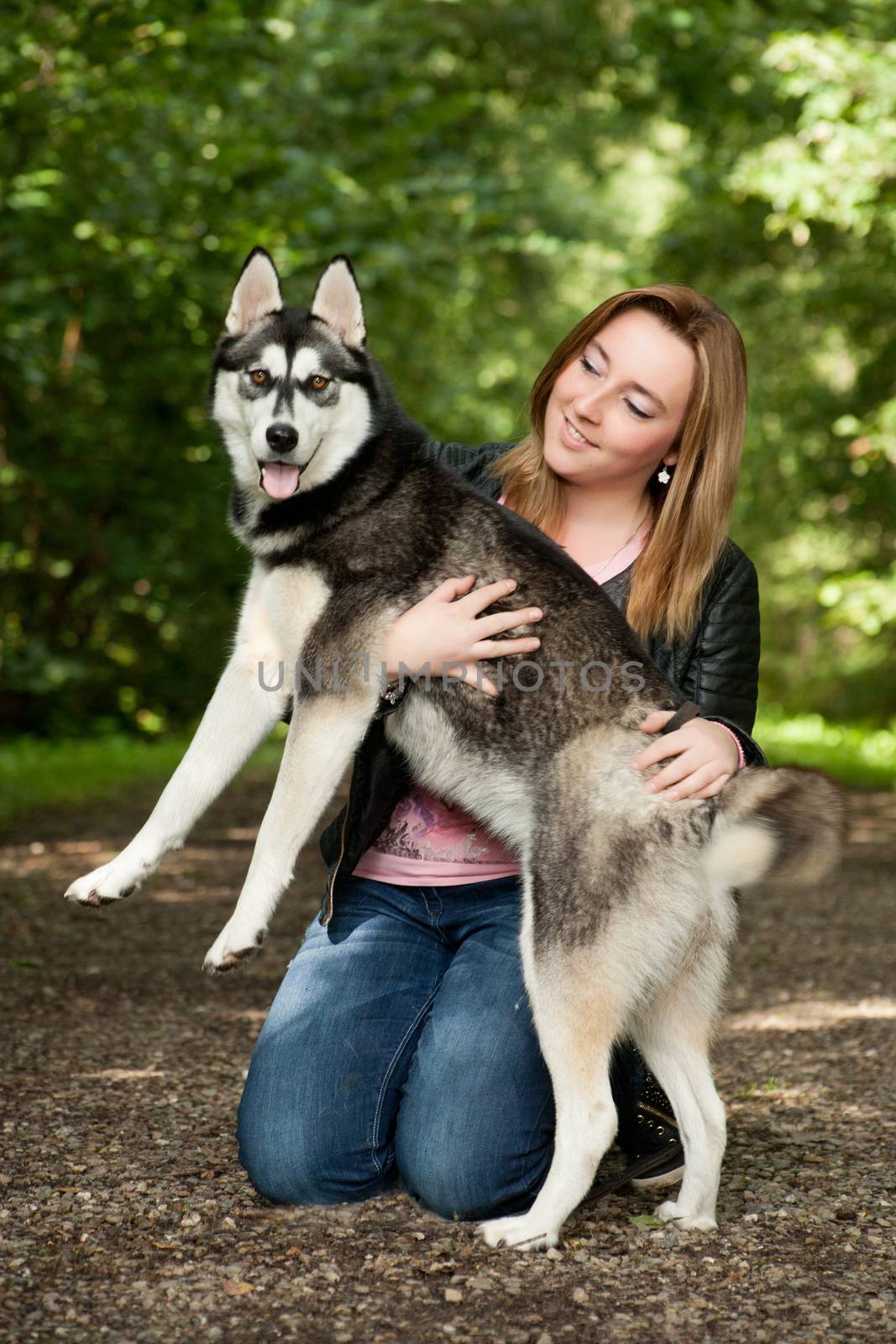 Young woman and her husky in the forest