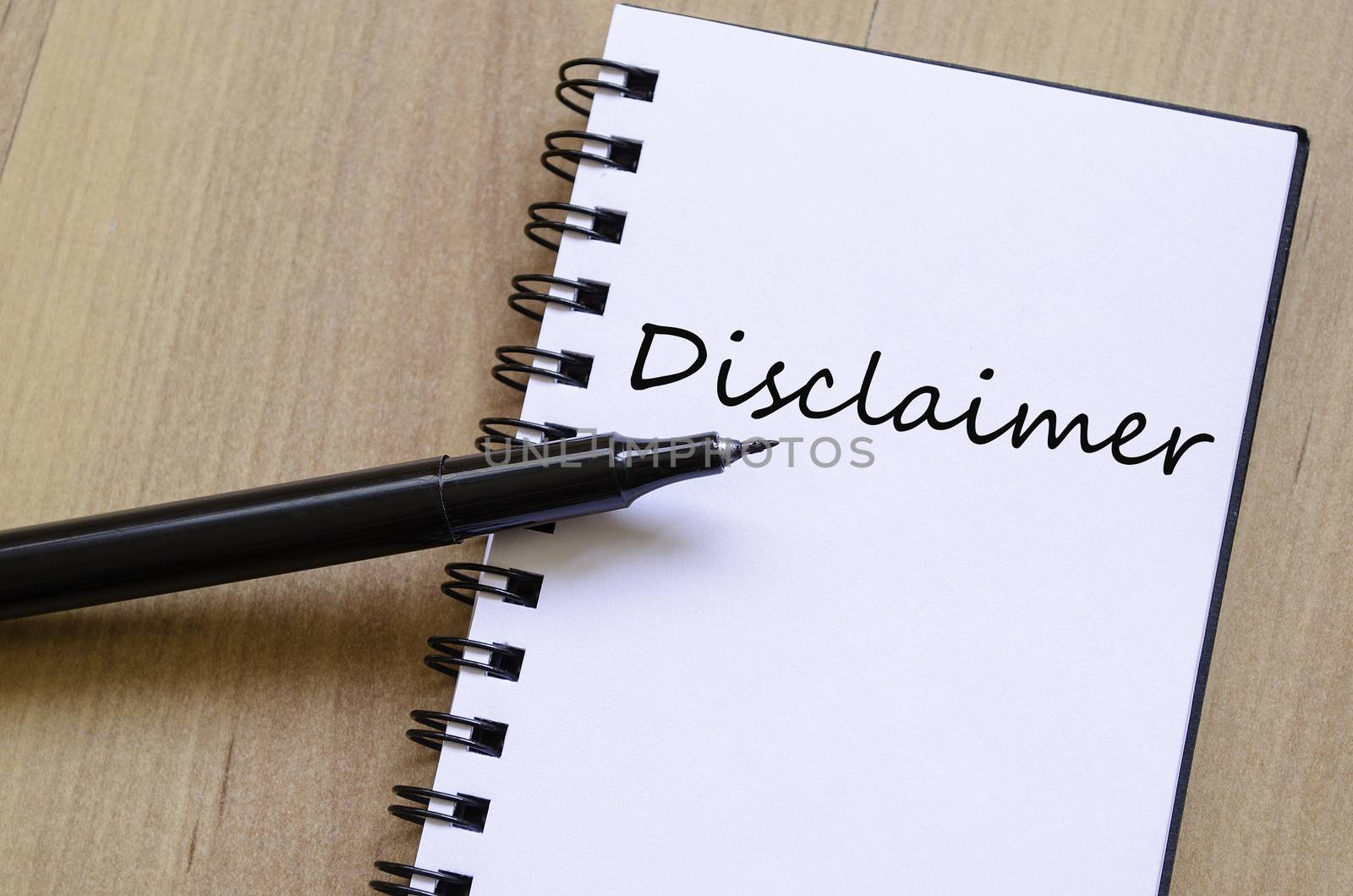White notepad and ink pen on the wooden desk Disclaimer Concept Notepad