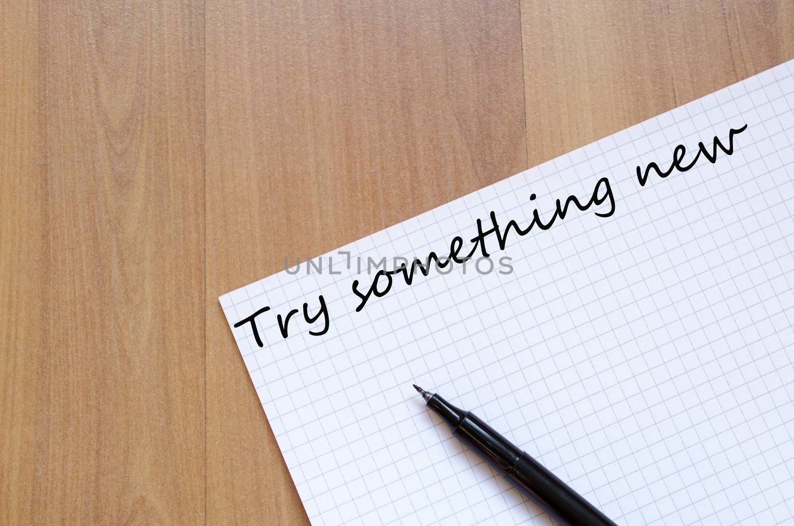 White blank notepad on office wooden table Try something new concept
